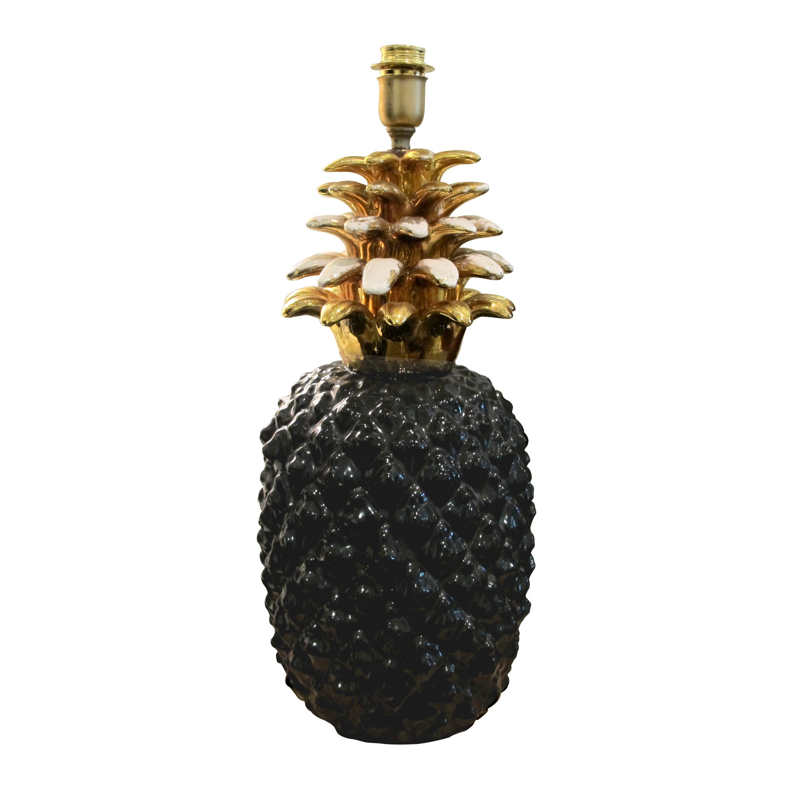 Highly decorative very large French black and gold ceramic pineapple table manufactured by Maison Lancel in the 1970s. The gold pineapple leaves have acquired a beautiful patina commensurate with age. The lamp is newly rewired to the UK standard.