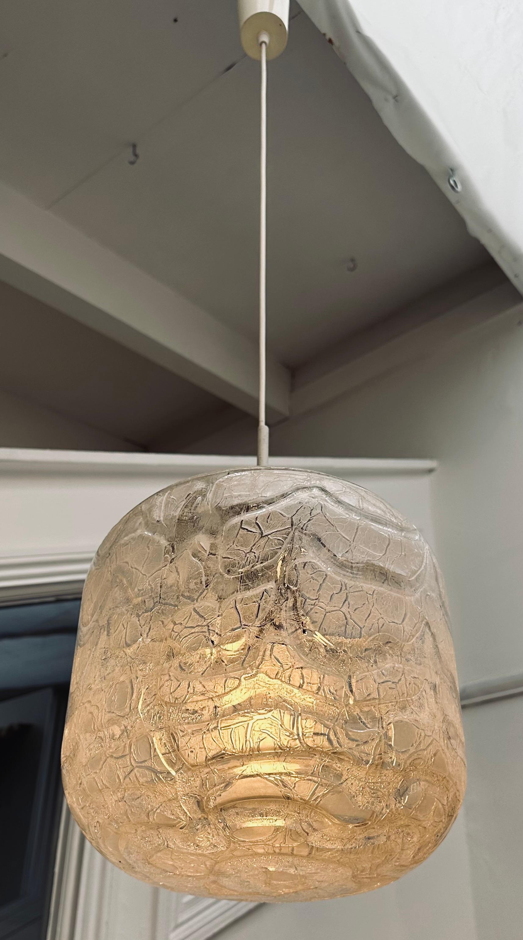 1970er Jahre Große zylindrische Hängelampe aus strukturiertem Eisglas mit Craquelé, hergestellt von Doria Leuchten in Deutschland. Der Schirm hängt an einem weißen Kabel mit einem passenden Deckenbecher, der die Drähte an der Decke verdeckt.  Eine