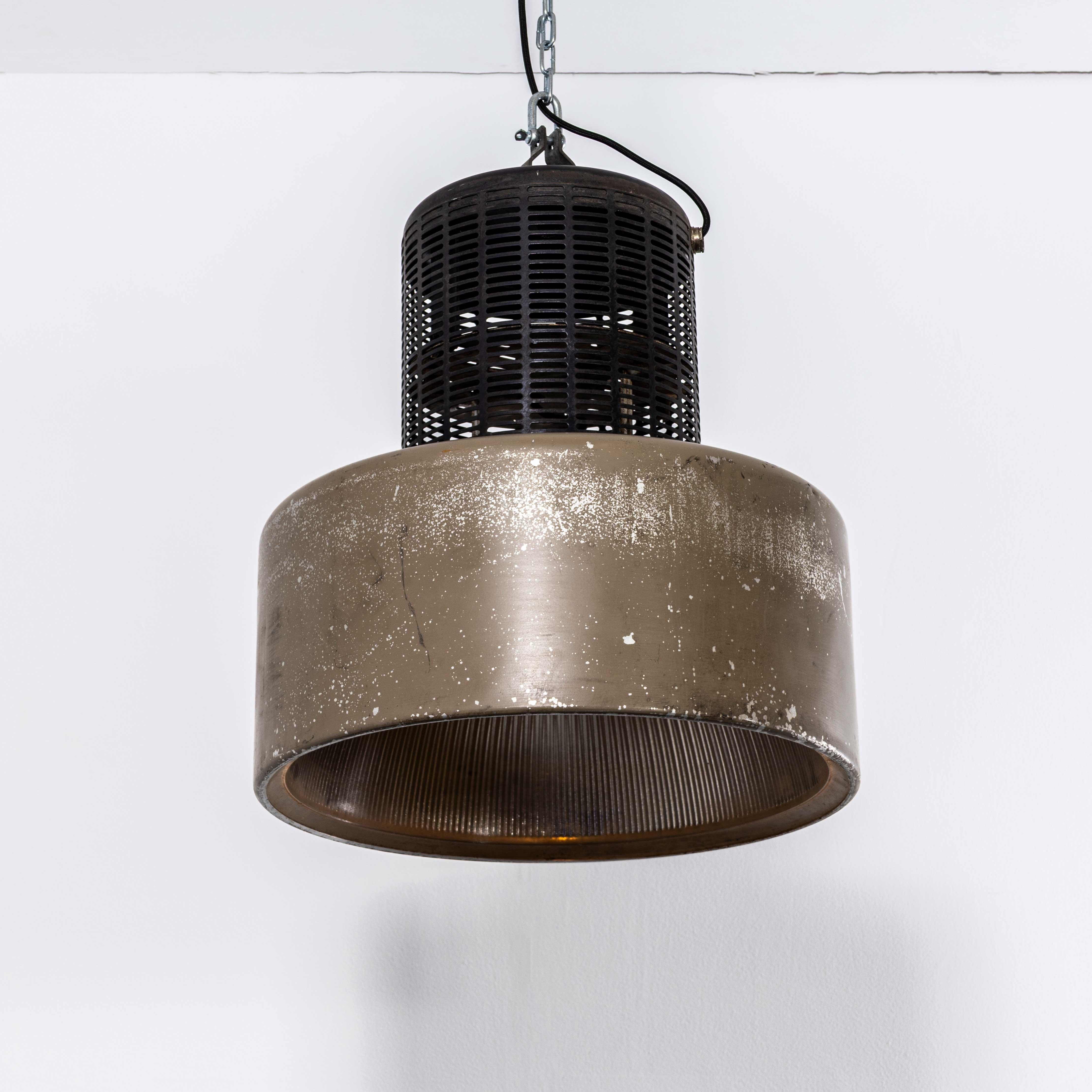 Grandi lampade a sospensione industriali Holophane degli anni '70 con griglia. Holophane è stata fondata in Francia alla fine del XIX secolo ed è famosa per aver inventato e perfezionato i riflettori in vetro borosilicato, spesso con intricati