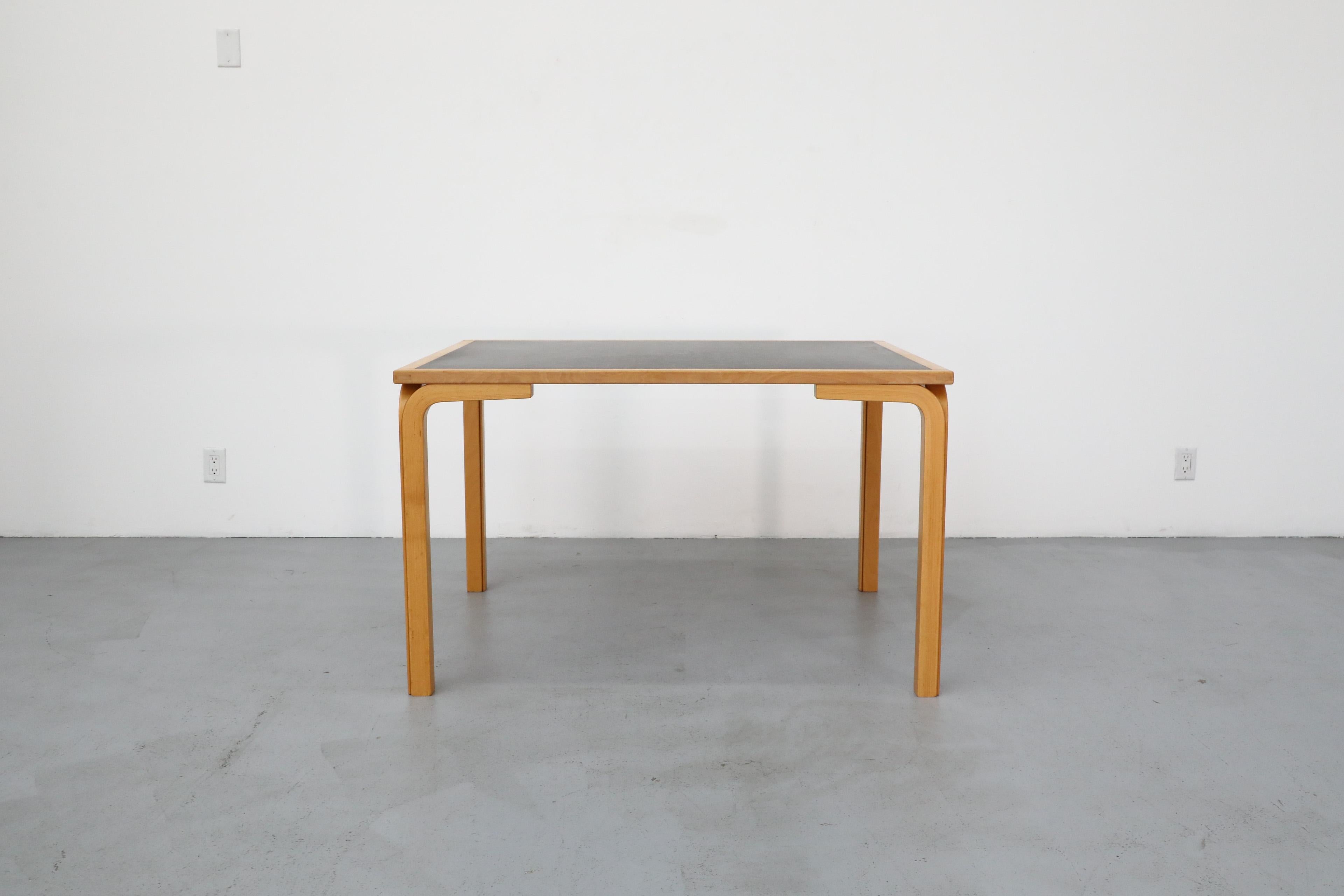 Mid-Century Magnus Olesen dining table by Rud Thygesen & Johnny Sørensen with bent Birch legs and black Formica inset top. In original condition with visible wear including some staining to the inset Formica, and wear to the frame. Wear is