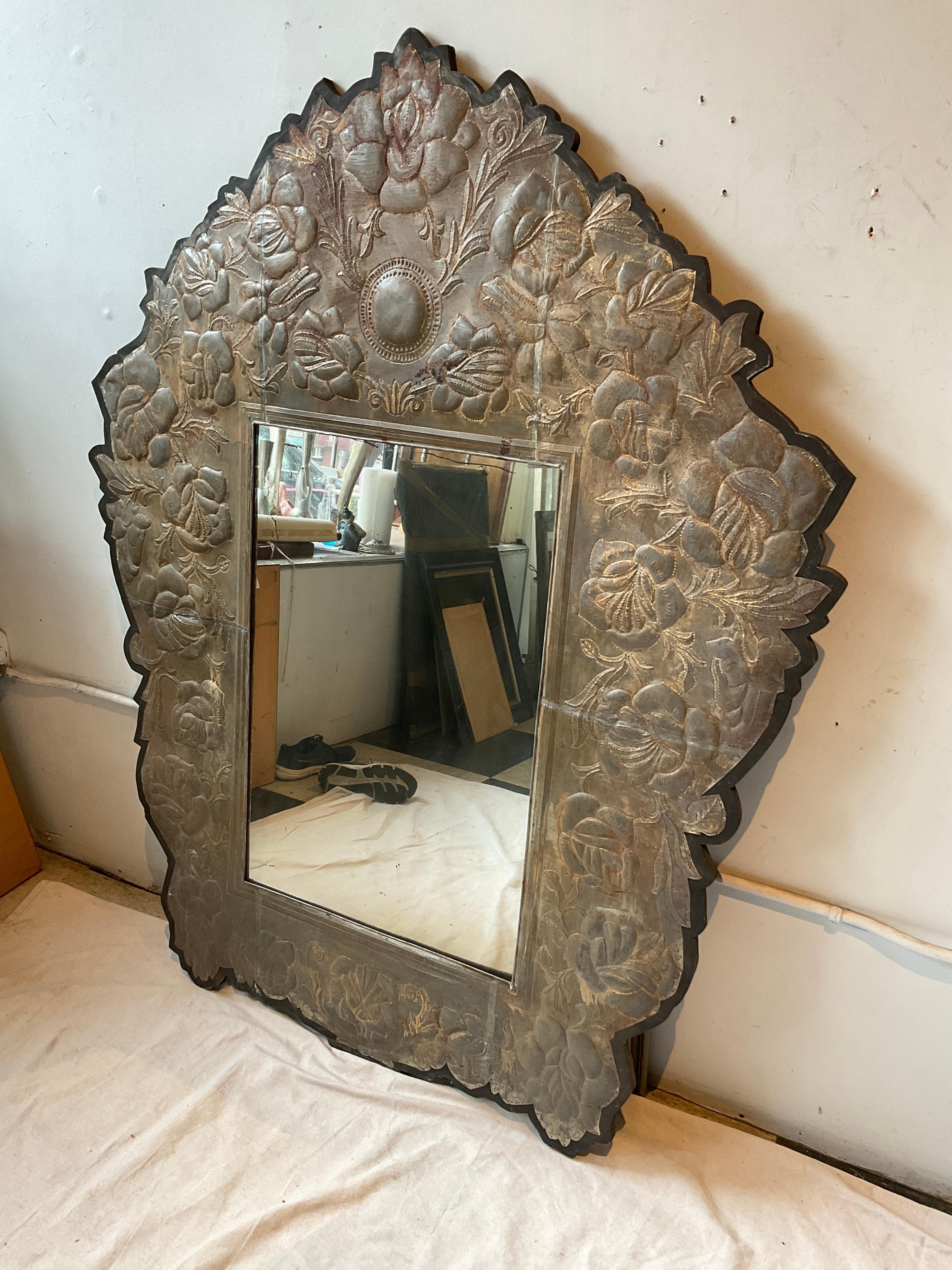 1970s Mexican tin floral mirror. Tin adhered to wood.
The mirror part swings open, it somehow nods to be fixed in place.