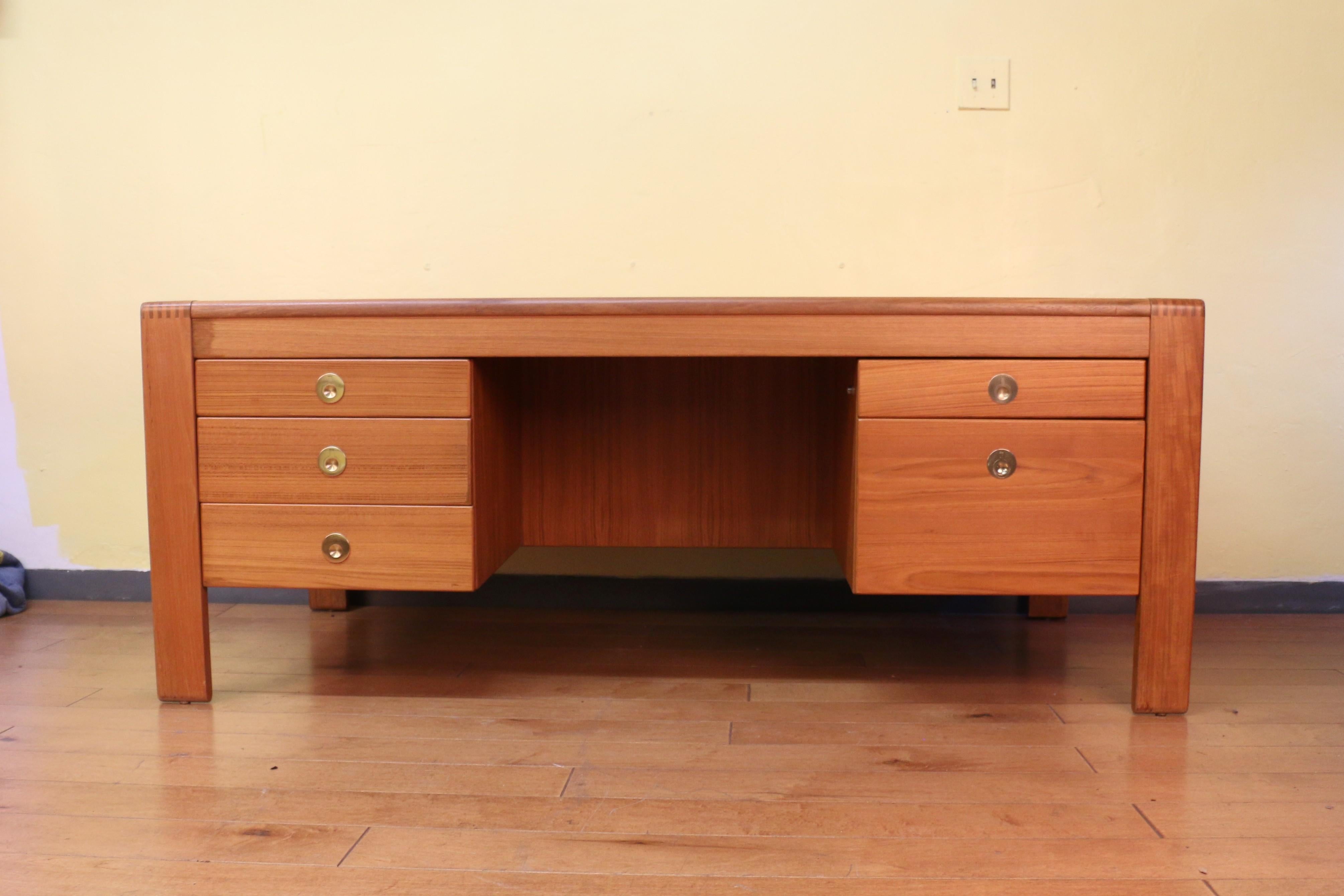 Scrivania direzionale Majestic progettata da D-Scan, (non ha il marchio del produttore). Questa splendida scrivania è realizzata in teak con splendide venature del legno e presenta un'eccezionale giuntura a pettine. Dispone di cinque cassetti che