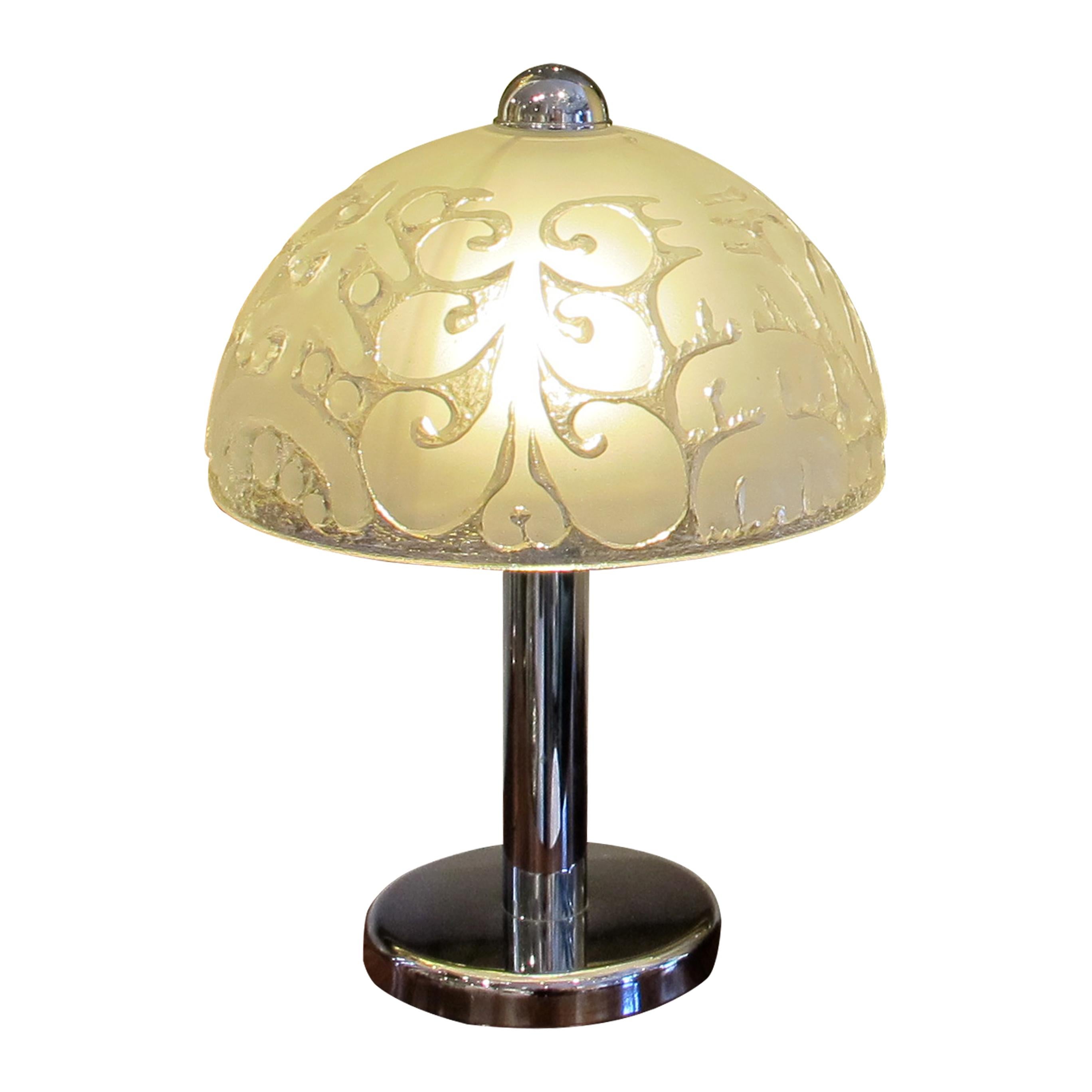 Elegant pair of 1970s chrome table lamps with glass dome shades. Each lamp features a sleek and polished chrome base that supports a large, dome-shaped shade made of frosted glass. The shades are textured with a leaf design, adding a subtle organic