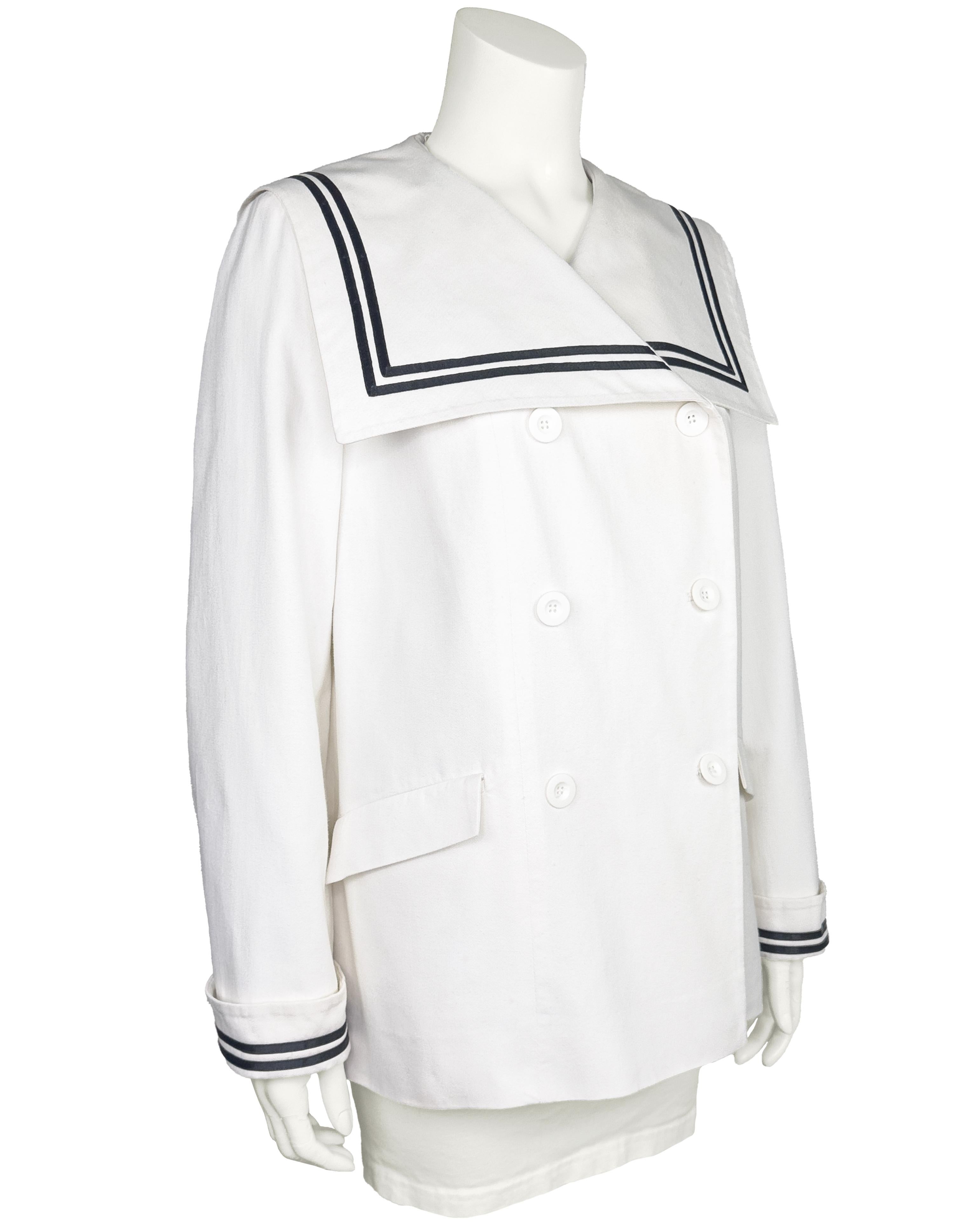 Très jolie veste de marin en twill de coton blanc Laura Ashley des années 1970. Double boutonnage avec un grand col marin plat et large. Double bande insérée dans un ruban bleu marine au niveau du col et des poignets repliés. Gros boutons ronds en