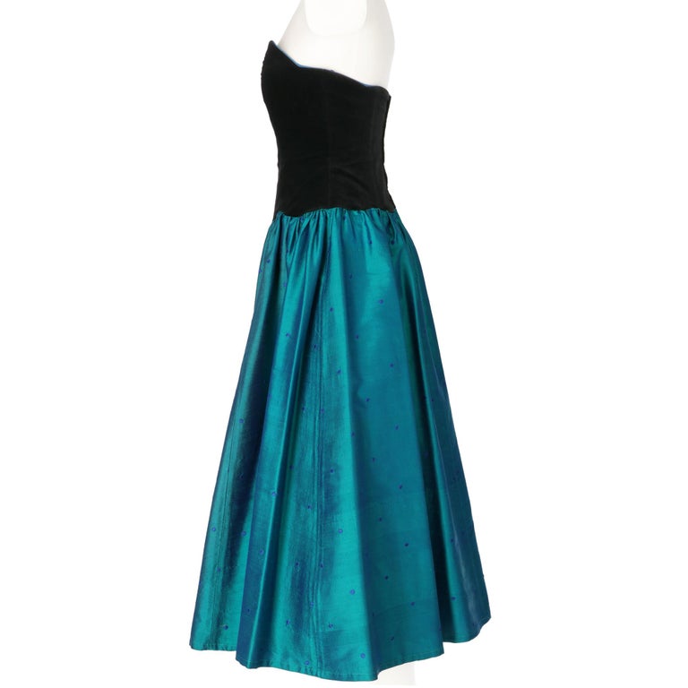 Laura Ashley empire-shaped dress, strapless black velvet top with wavy hem, and emerald green silk shantung bell skirt with blue polka dots, back zip closure.

Year: 70s

Made in Great Britain 

Size: 40 IT

Linear measures

Height: 107 cm 
Bust: 39