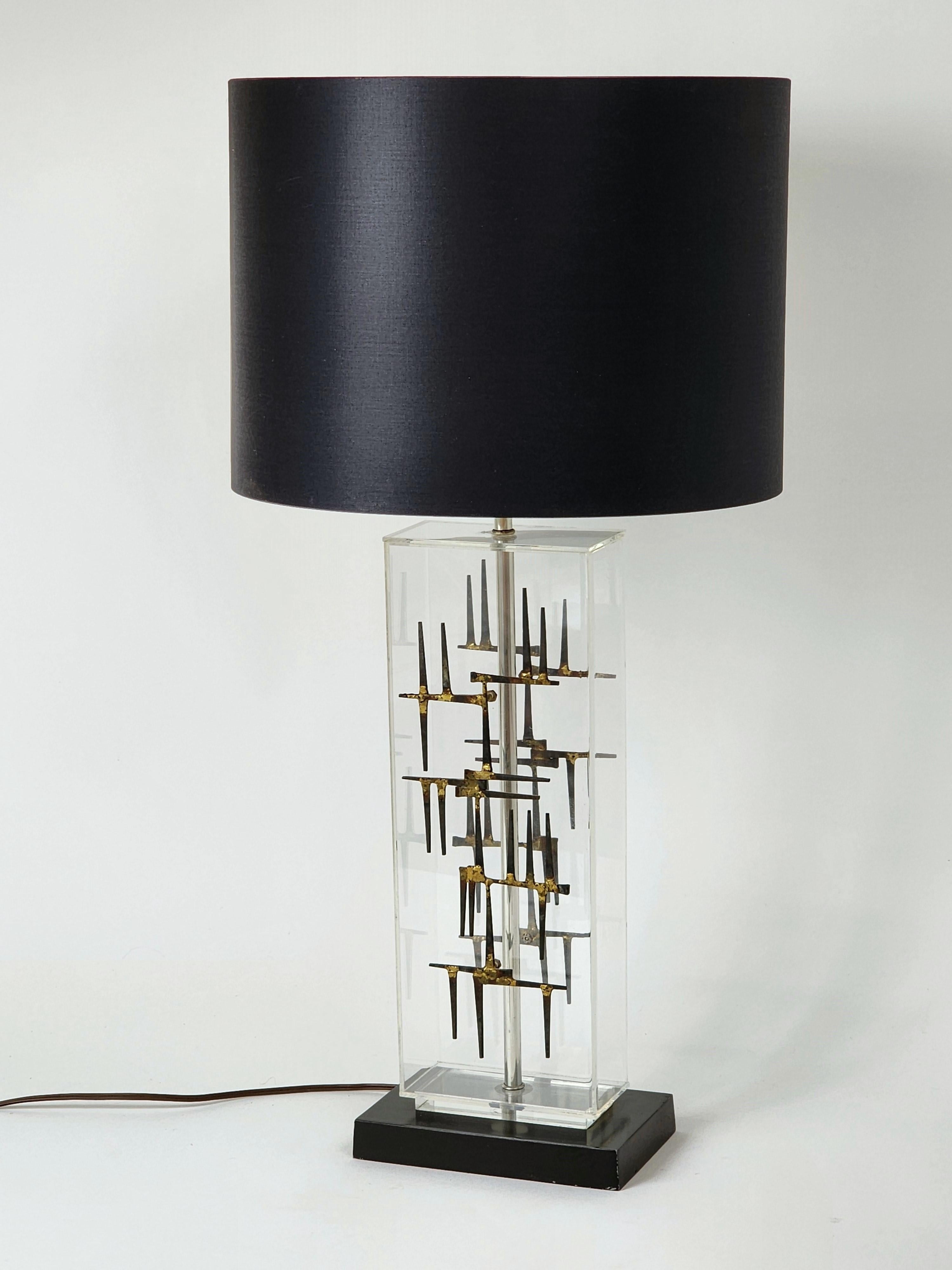 Rare ' Laurel ' brutalist table lamp made of  cut nail mounted on clear acrylic sheet . 

A  nice ,  bold  touch  of  modernity blended with  raw sculptural brass welded cut nail that seems suspended in the air under the shade . 

Shade supplied