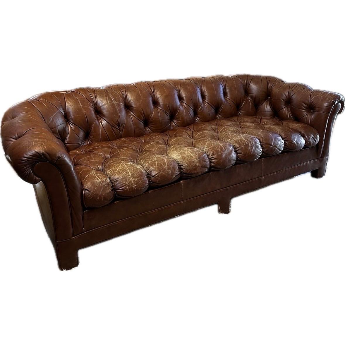 This 1970s leather Chesterfield sofa is a timeless piece of furniture that has endured the test of time. With its deep button-tufted leather upholstery, rolled arms, and distinctive trim, this sofa exudes a sophisticated and masculine charm that has