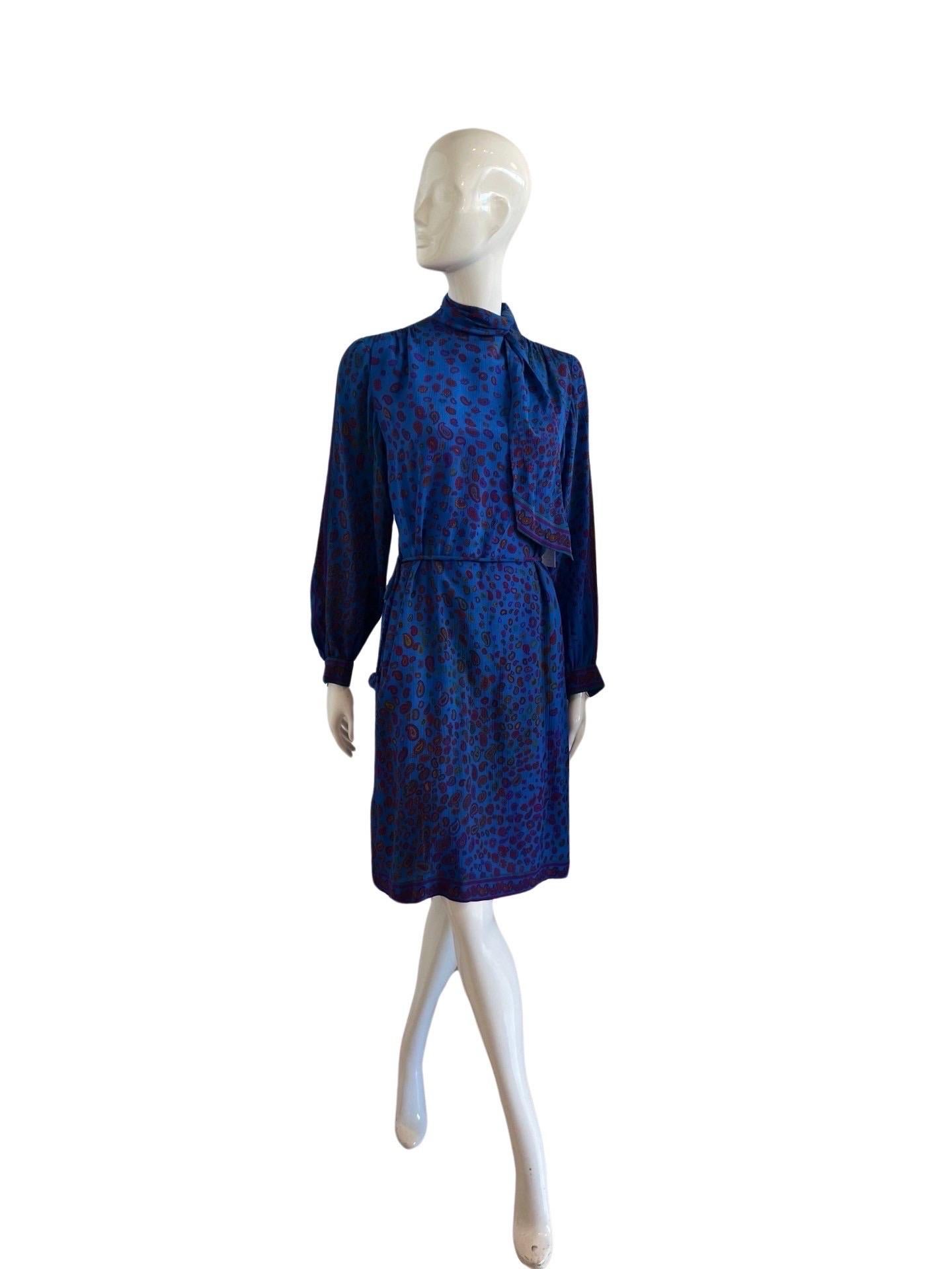 Stunning 1970's Leonard Paris Studio line in an electric deep blue on crepe silk with a fuscia and burgundy paisley print.  The dress has a high collar  and an attached scarf piece to be tied at the side of the neck.  The dress zips down the back. 