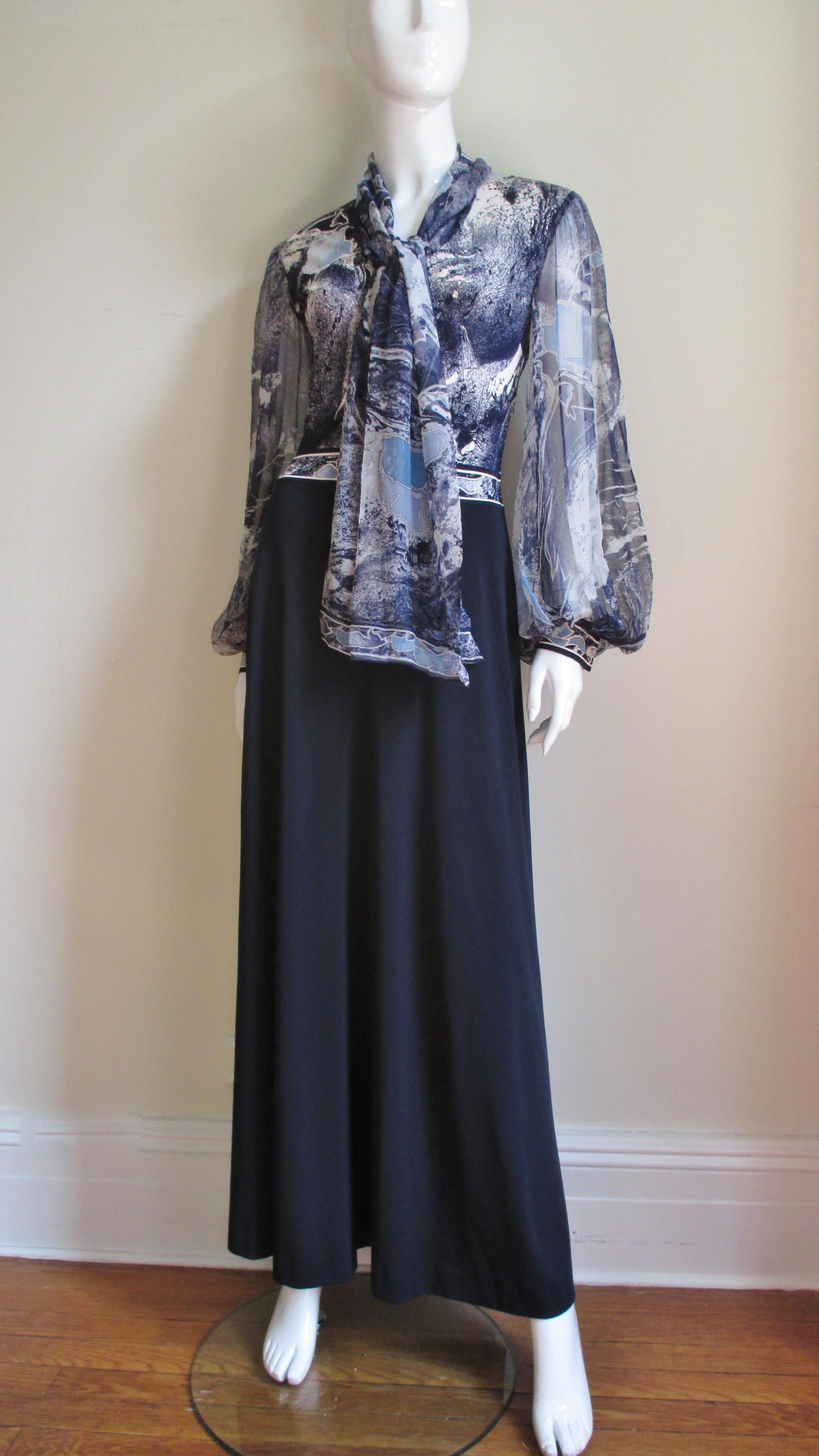 A beautiful jersey maxi dress from Leonard, Paris. The silk bodice is in an abstract blues and off white print with large flowers.  It has ties at the neck and semi sheer full billowing sleeves.  The cuffs and center front bodice close with small