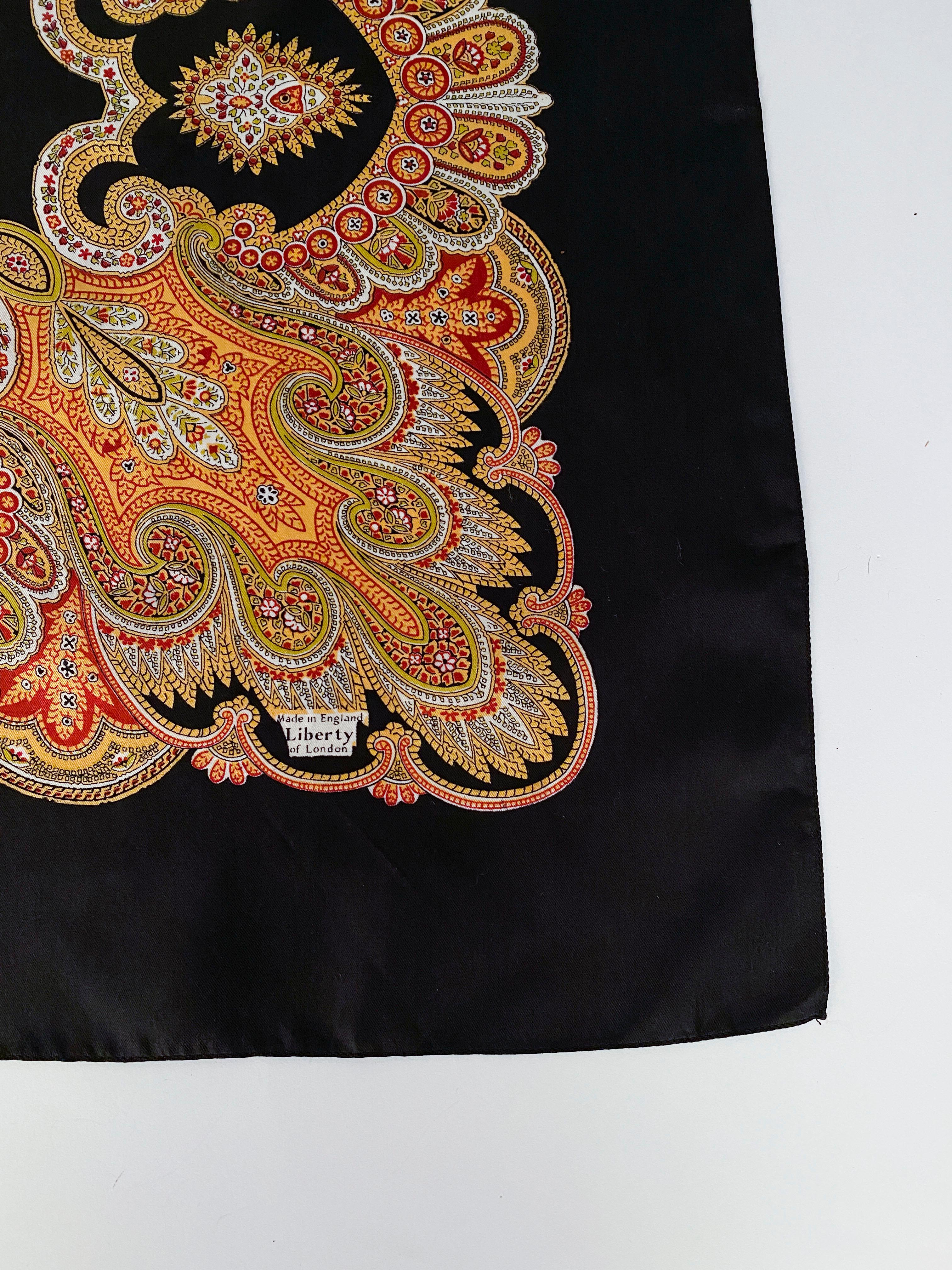 1970s Liberty of London silk printed scarf the features red, gold, and cream-toned paisley that contrast the black forecolor. 