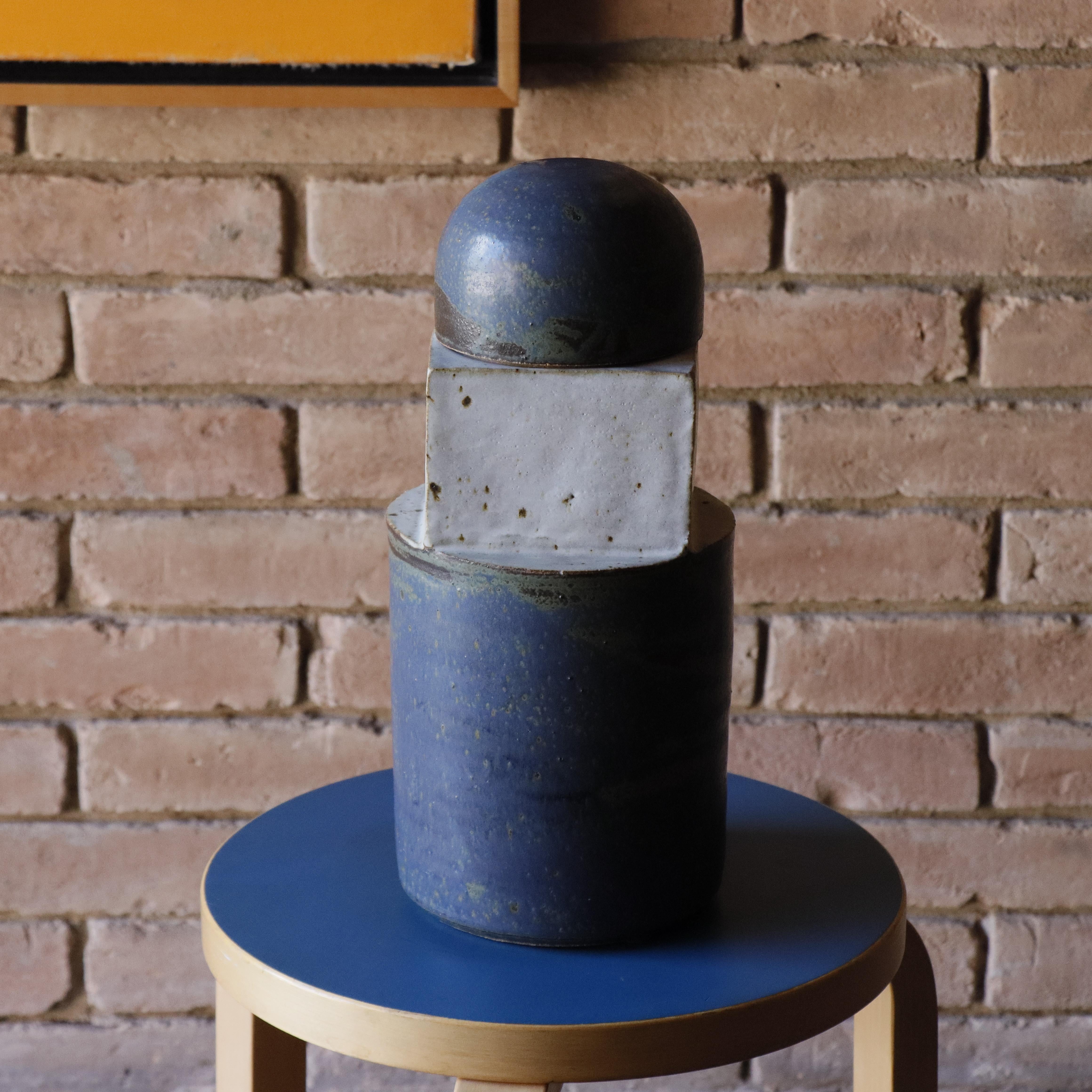 Questo sorprendente vaso con coperchio è un'opera autentica di Gerry Williams (1926-2014), artista americano pioniere della ceramica e fondatore della rivista Potter Studio. Rinomato per il suo approccio innovativo alle tecniche di smaltatura e per