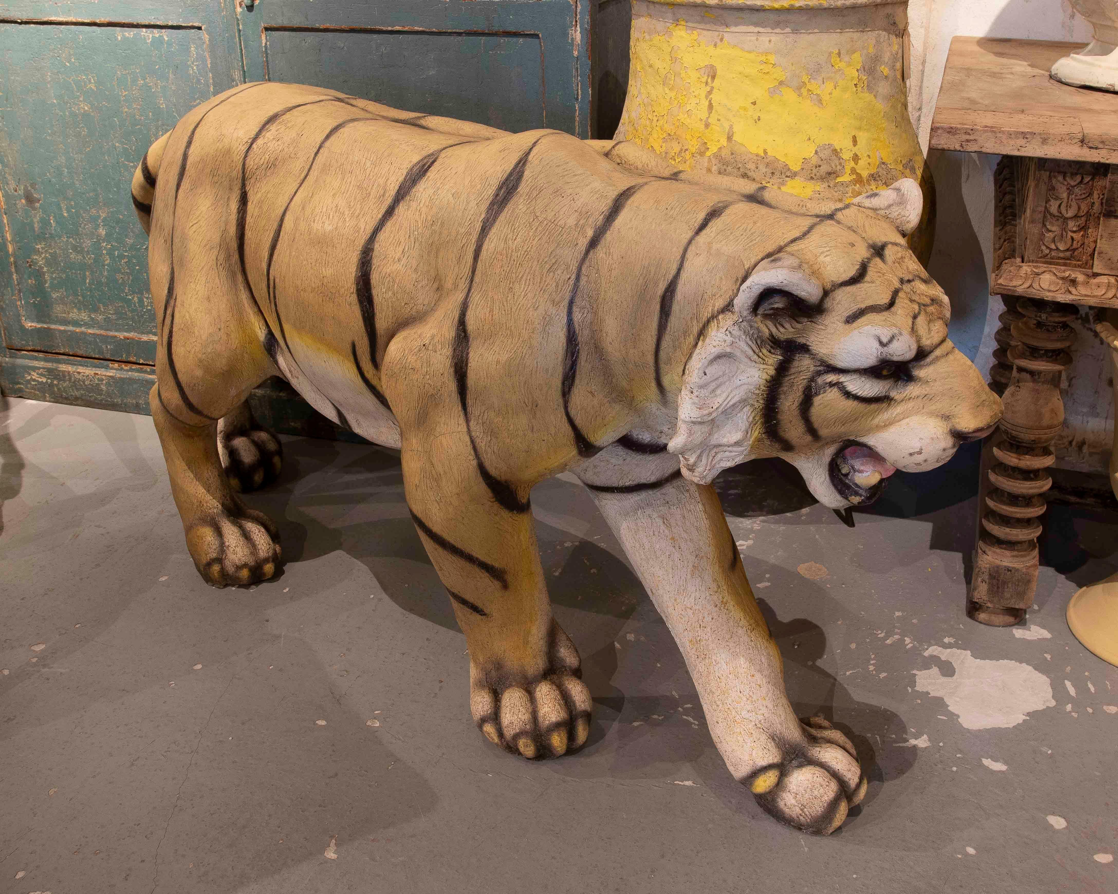 Impresionante escultura a tamaño natural de un tigre, cuidadosamente elaborada con detalles que reflejan la textura del pelaje y los rasgos distintivos del animal. Su pose dinámica y expresiva transmite fuerza y movimiento, captando la esencia de