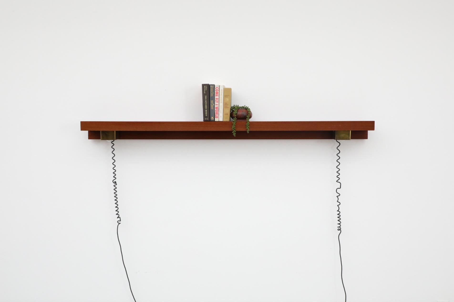 D'une élégance discrète, ce bandeau lumineux mural minimaliste en laiton et teck des années 1970 illuminera n'importe quel espace. Le design épuré et minimaliste permet aux deux lampes encadrées de laiton de glisser horizontalement le long d'un