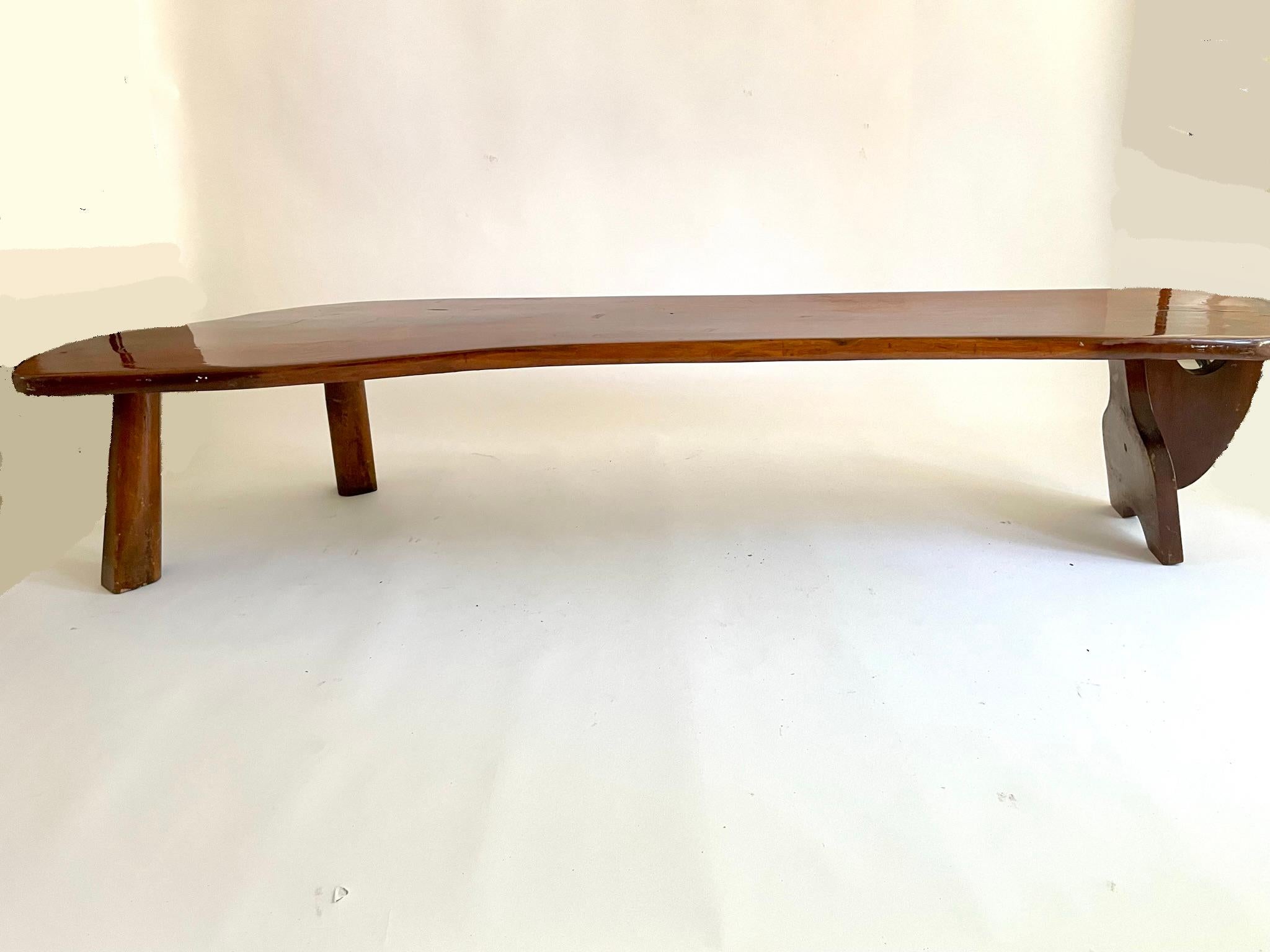 This organic shaped live edge coffee table is from the 1970s. There are interesting construction details, butterfly joinery, tenon and pegs to construct the table without nails. The wood is walnut with a resin finish.