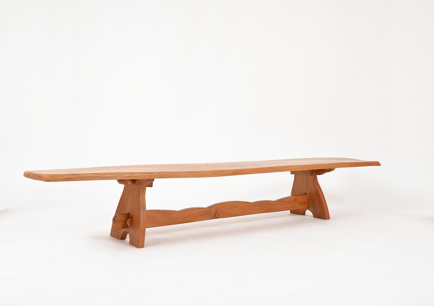 A really beautiful craftsman made 1970s long and low solid elm bench or low table. Of traditional pegged construction, with a wonderful waney edge and beautiful natural figuring to the top. The gentle corrugated stretcher is secured with a pegged