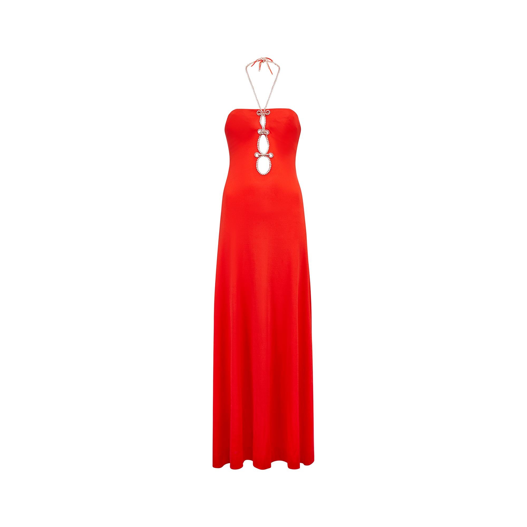 Fabuleuse robe longue en jersey rouge des années 1970, signée Loris Azzaro, présentant un profond trou de serrure sur l'encolure avant, rehaussé de cristaux diamantés pour un effet glamour. Celles-ci se poursuivent le long des bretelles du dos nu,