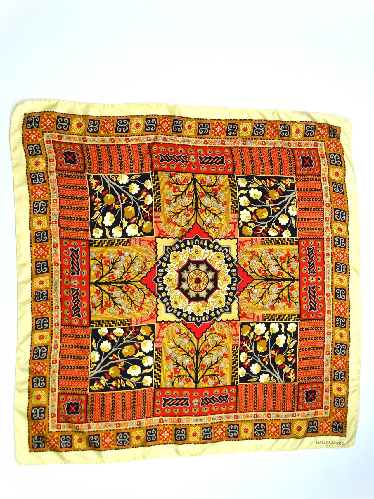 Magnifique et rare foulard en soie Loris Azzaro des années 70, aux riches couleurs or, corail, noir, rouge et marron. Cette écharpe a un imprimé qui me rappelle un
 