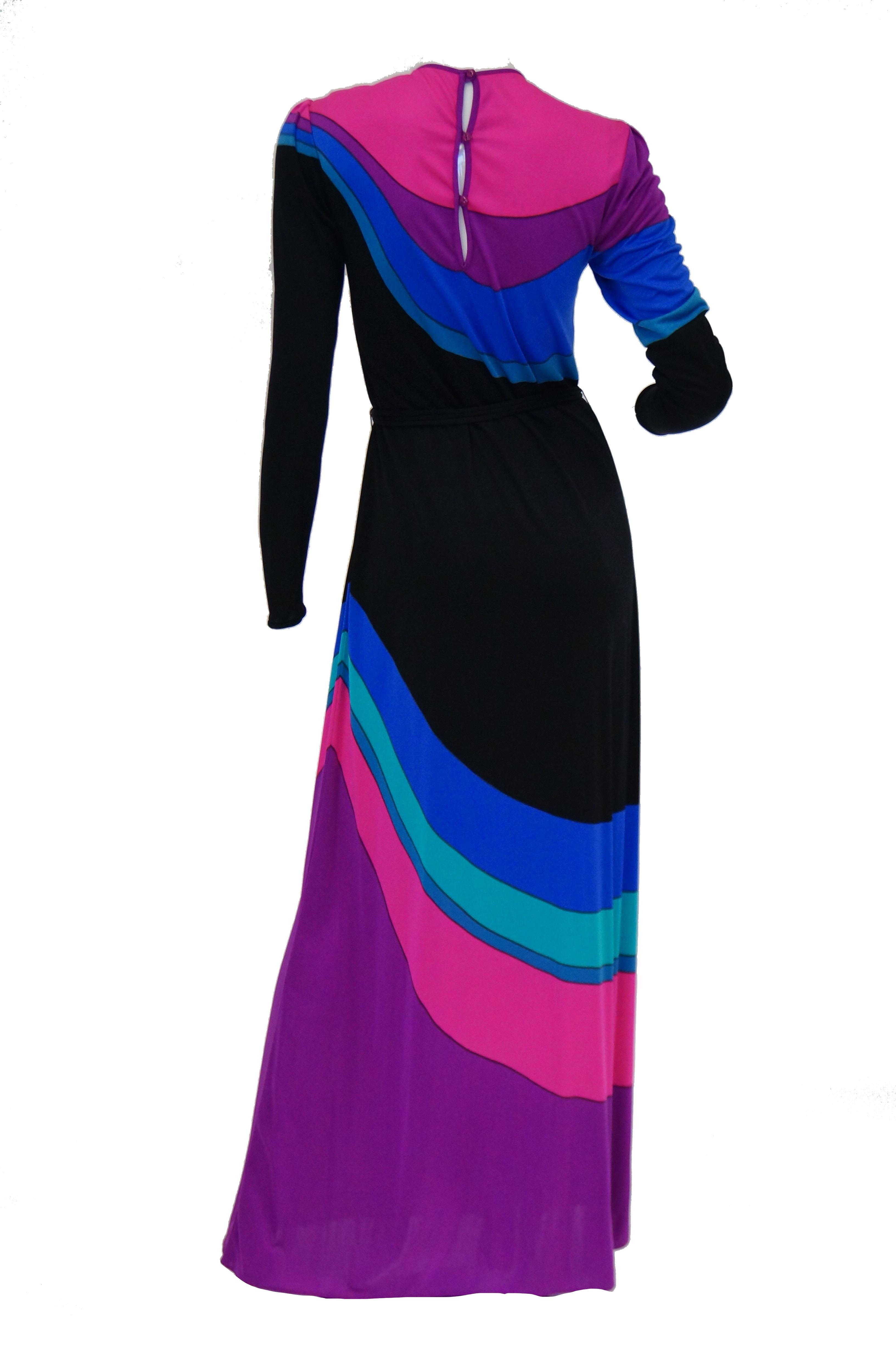 Brilliant late 1970s slinky knit maxi dress by Louis Feraud! The dress has long sleeves, a jewel collar, and a cinched waist further accented by a knit tube belt. The dress features an amazing Peter - Max - style technicolor rainbow - like swirl