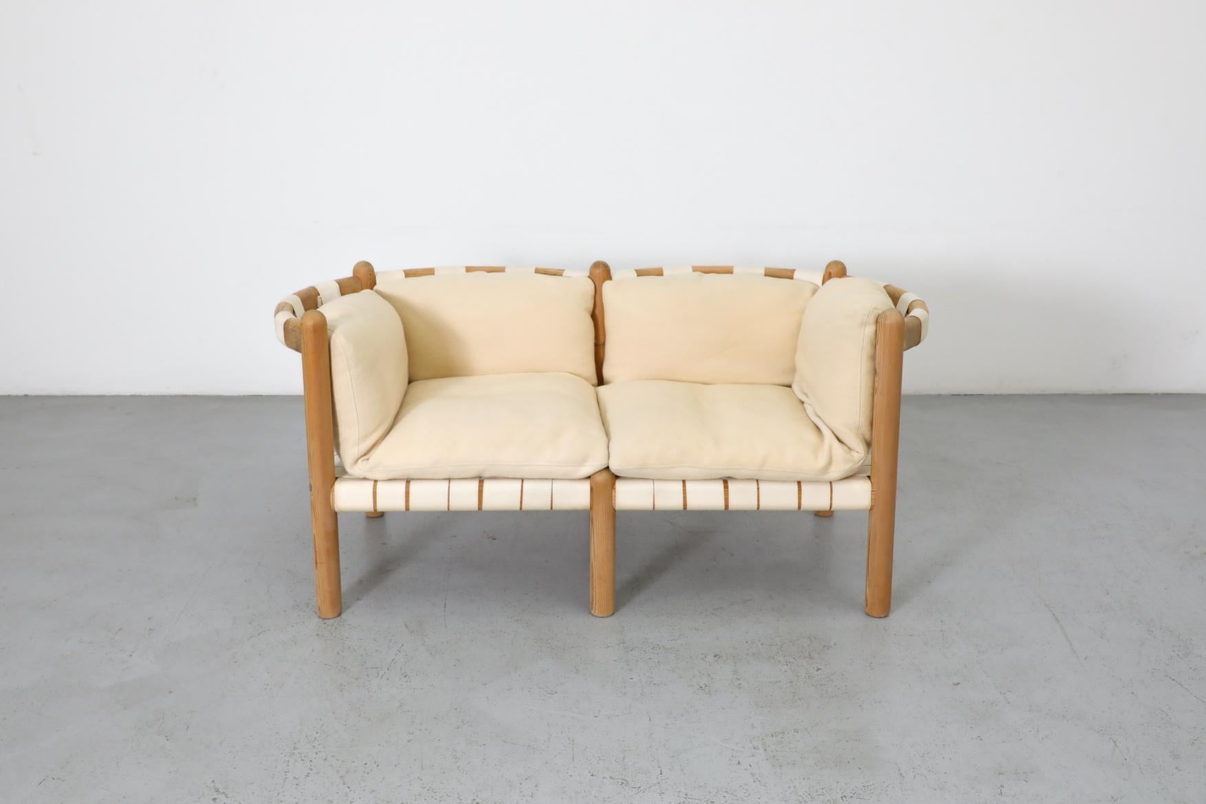 Rare 1970s loveseat designed by Rainer Daumiller featuring a beautiful solid pine frame with vertical columns and sweeping curved seat backs. In original condition with original wool cushions and strapping. The cushions on this love seat have
