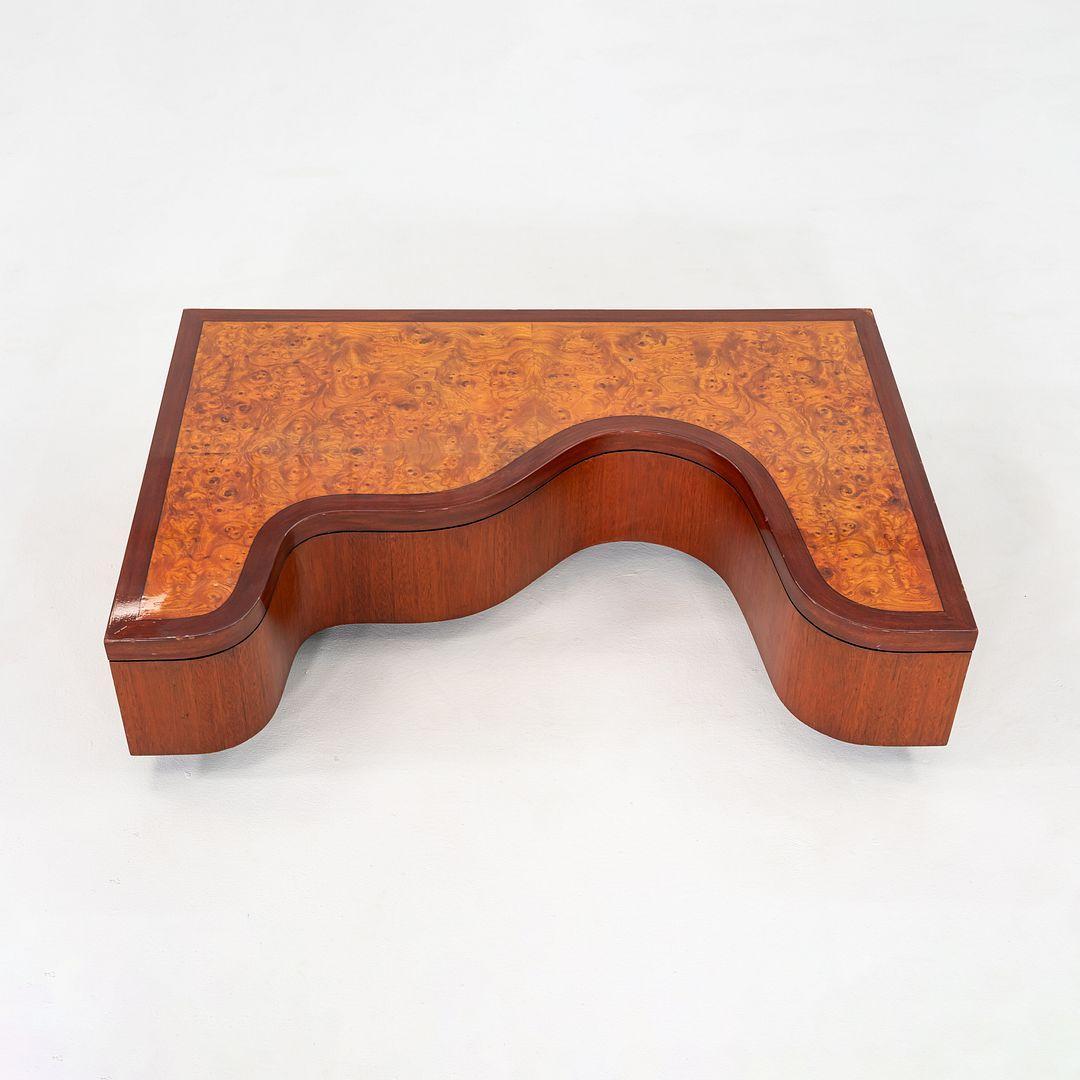 Il s'agit d'une table basse sculpturale, fabriquée à la main à partir de ronce, de noyer et d'acajou. L'une des faces de la pièce est ornée d'un motif ondulé, une prouesse impressionnante pour un travailleur du bois. La pièce n'est pas signée. 
 
