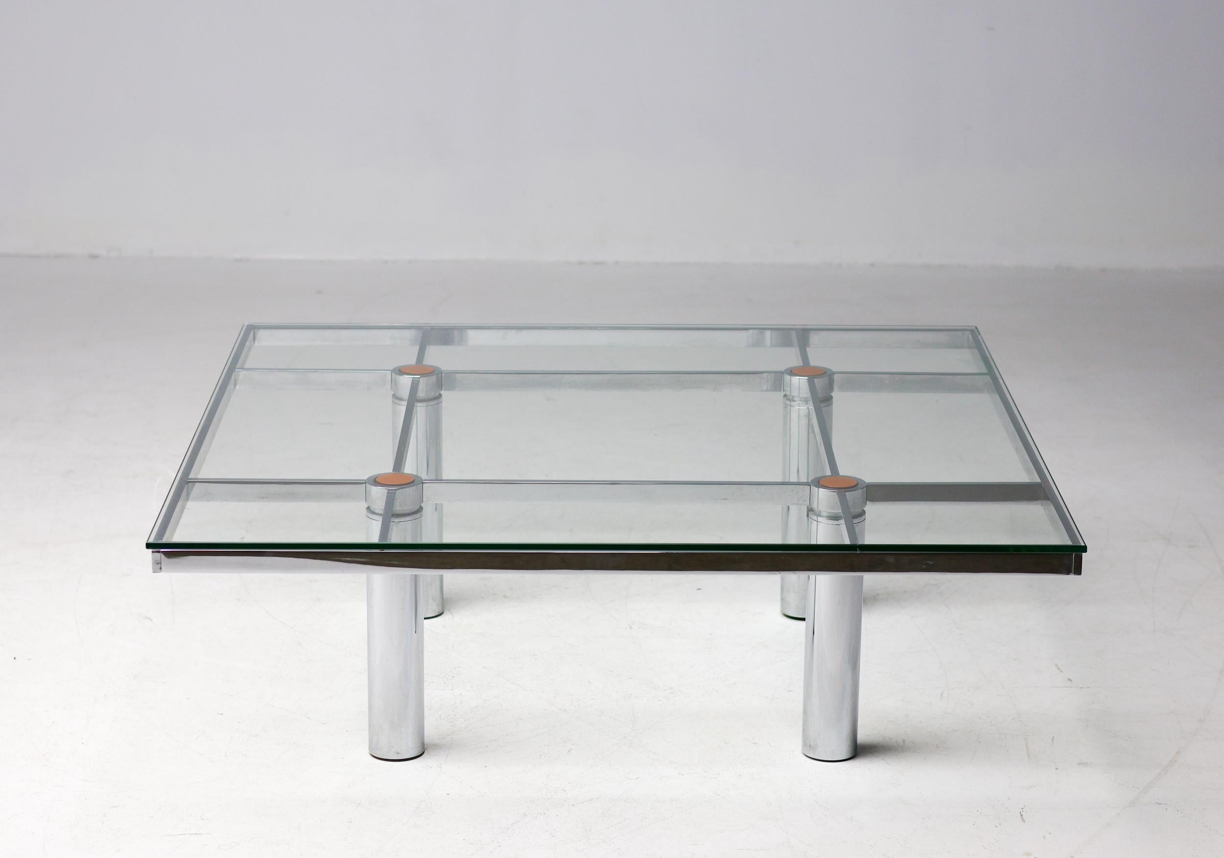 Monumental square low table with a gridded architectural chromed steel base supporting a glass top.
A classic Tobia Scarpa design for Gavina/Knoll International.
Complete with the leather inserts in the legs supporting the glass top. These are