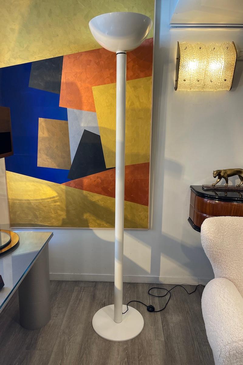 LUCE floor lamp from the 1970s, crafted in white enameled metal. The lamp can be adjusted in two positions: directed upwards or tilted sideways. 
Measurements: diam. 37.5 × h 197 cm.

Price INCLUDES the costs for any packaging and crates needed to