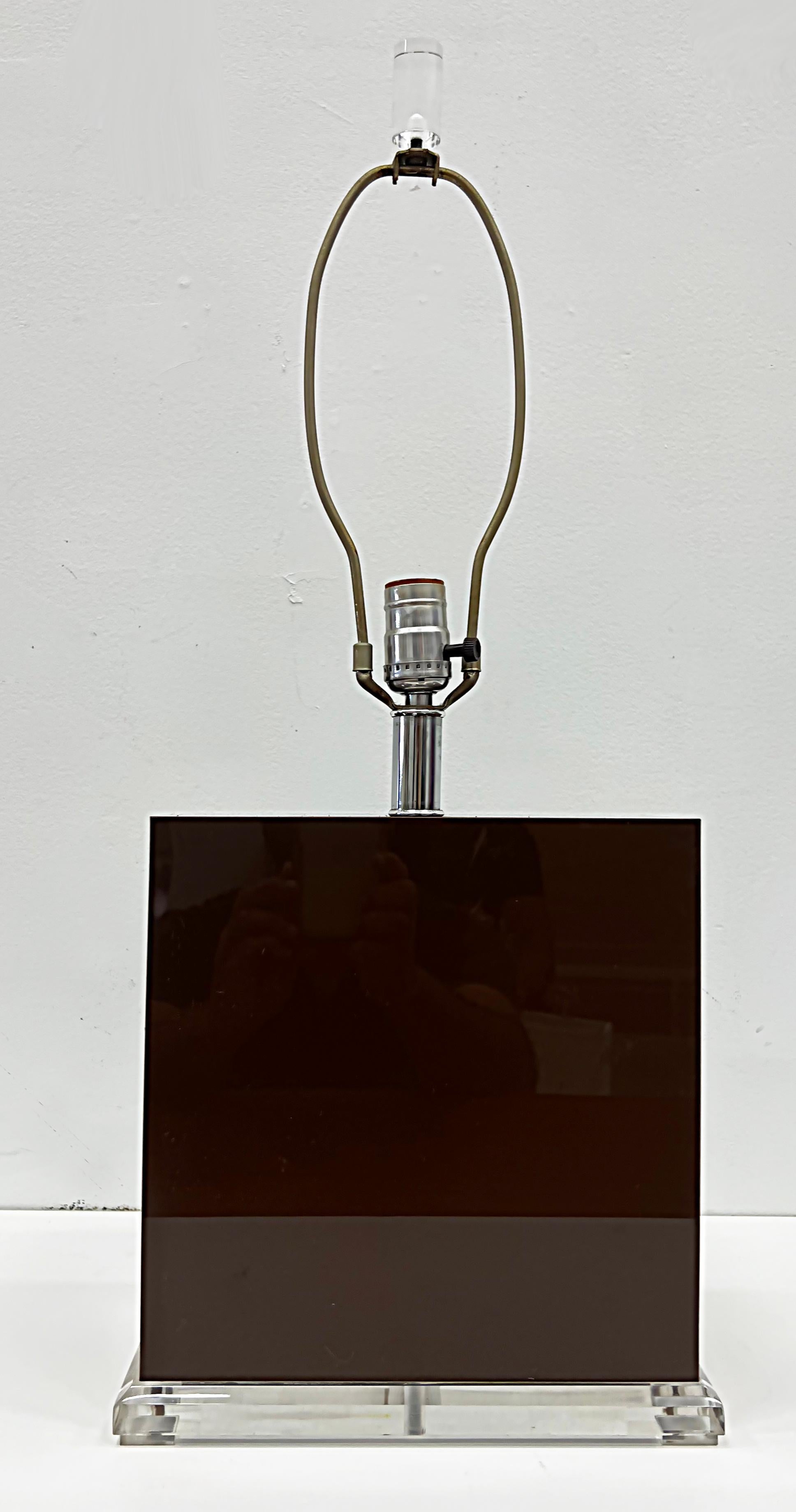 Offered for sale is a pair of 1970s chocolate brown acrylic and lucite table lamps. lamps have acrylic bodies and are presented upon Lucite bases. They have chrome fittings and Lucite finials. Each lamp accommodates a standard US light bulb and they