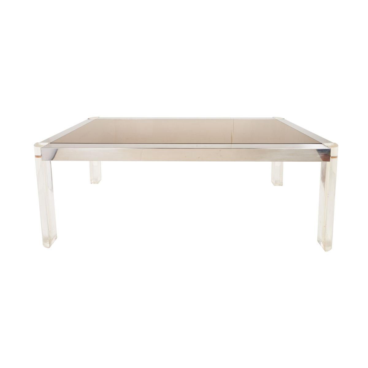Découverte en France, cette superbe table à manger est incroyablement chic. Le plateau en verre, le cadre chromé et les pieds en Lucite de ce design élégant et sexy sont la quintessence du style moderne italien. Il s'agit d'une pièce fabuleuse qui