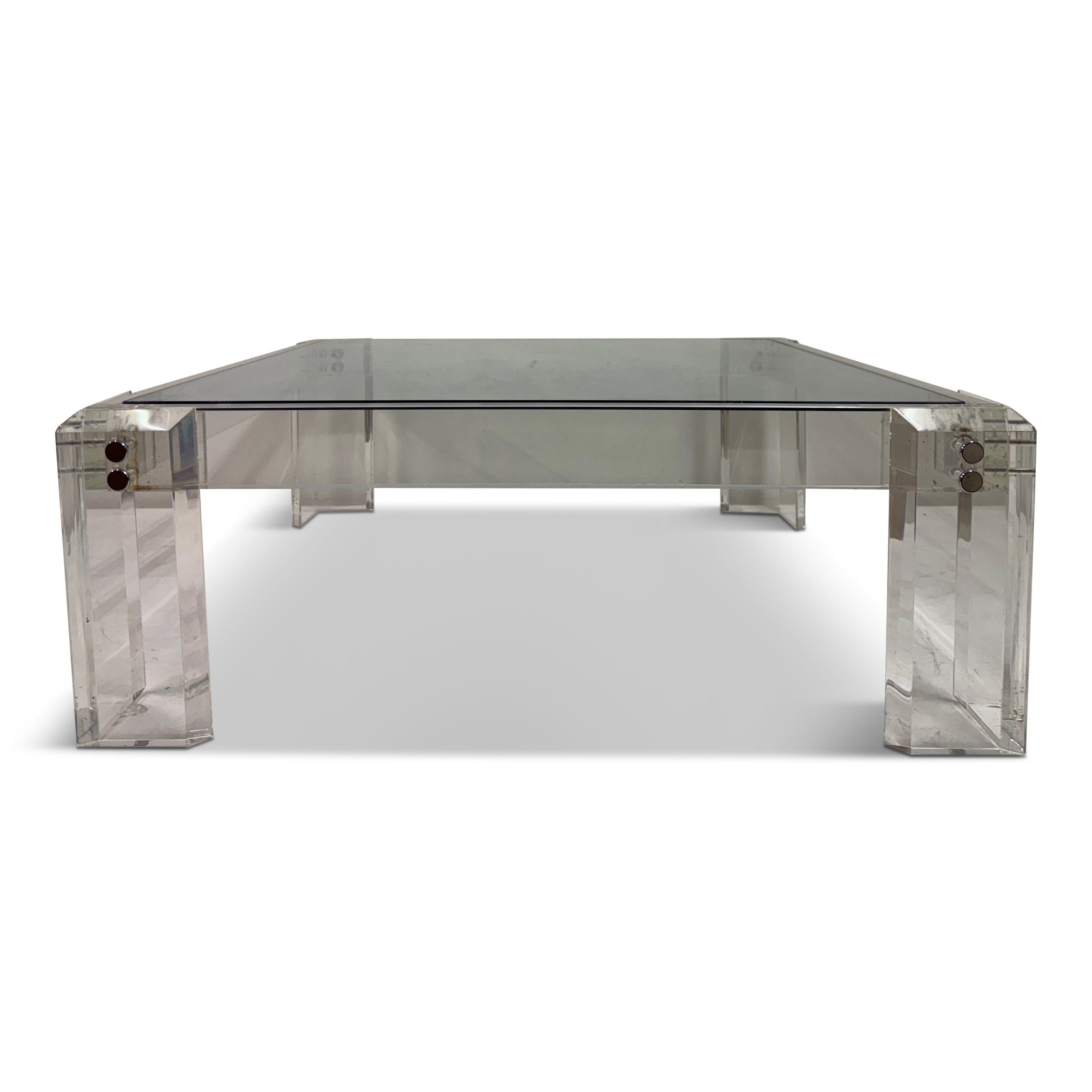 Couchtisch aus Lucit und Glas, amerikanisch, 1970er Jahre

Dieser Couchtisch ist ein raffiniertes Beispiel für amerikanisches Design der 1970er Jahre. Er besteht aus dicken, facettierten Lucite-Platten, die mit polierten Chrombeschlägen verbunden