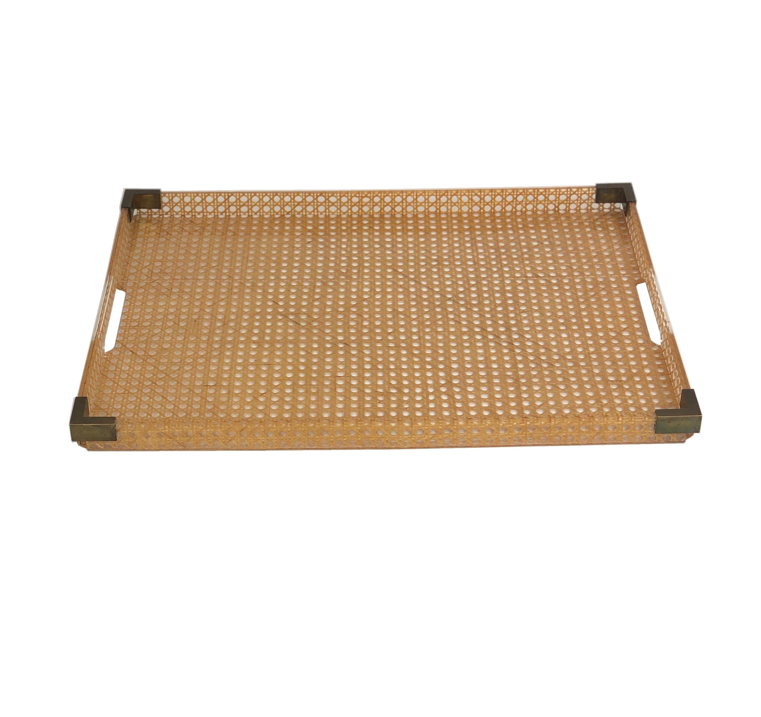 Elegant large butler serving tray made of Lucite and Rattan designed for Christian Dior Home collection in 1970s. Geometric shape with gilt brass gallery and real rattan cane-work embedded in the crystal clear Lucite. Corners are embedded with