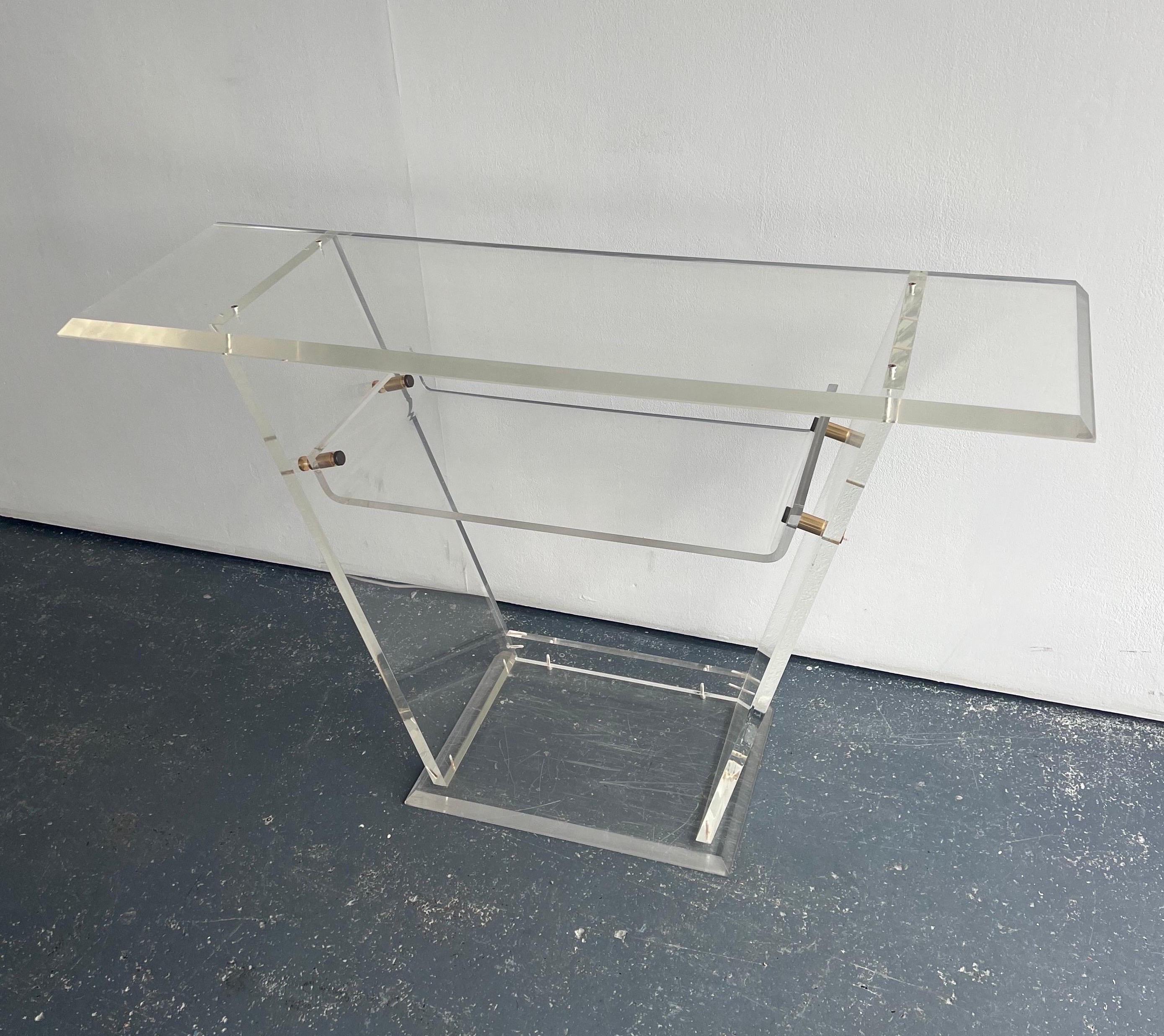 1970s Lucite and Brass Console Table with Shelf

A fabulous design that would look great in a hallway or living space. A very sleek lucite structure with elegant brass fixtures. In good condition, there are some scratches that are common with