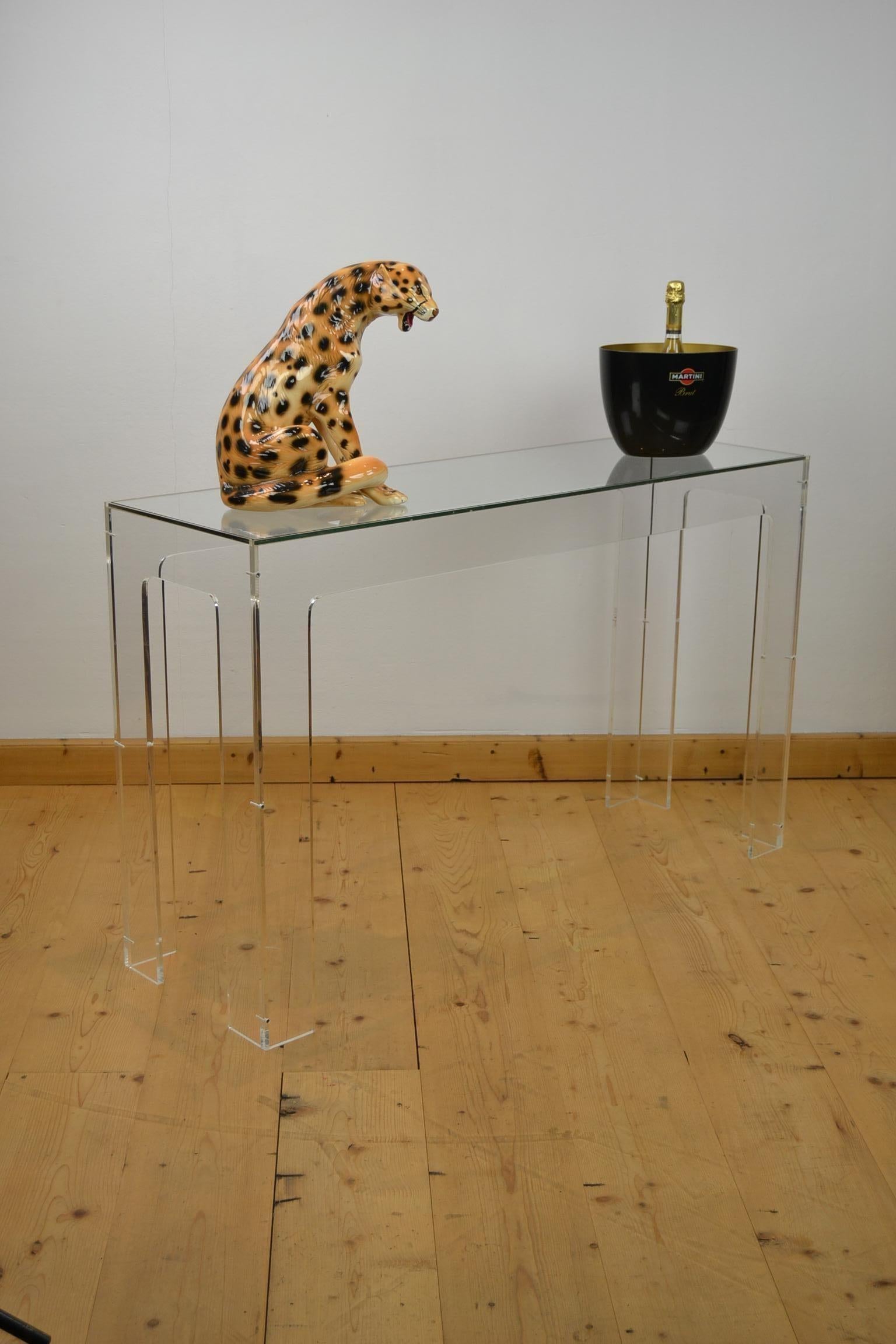 Vintage Lucite - plexiglass or acrylic console table with thick glass table top. 
This console table - side table or dresser dates circa 1970s.

Because of the material and minimalistic design, 
this kind of console tables fit great in a Modern