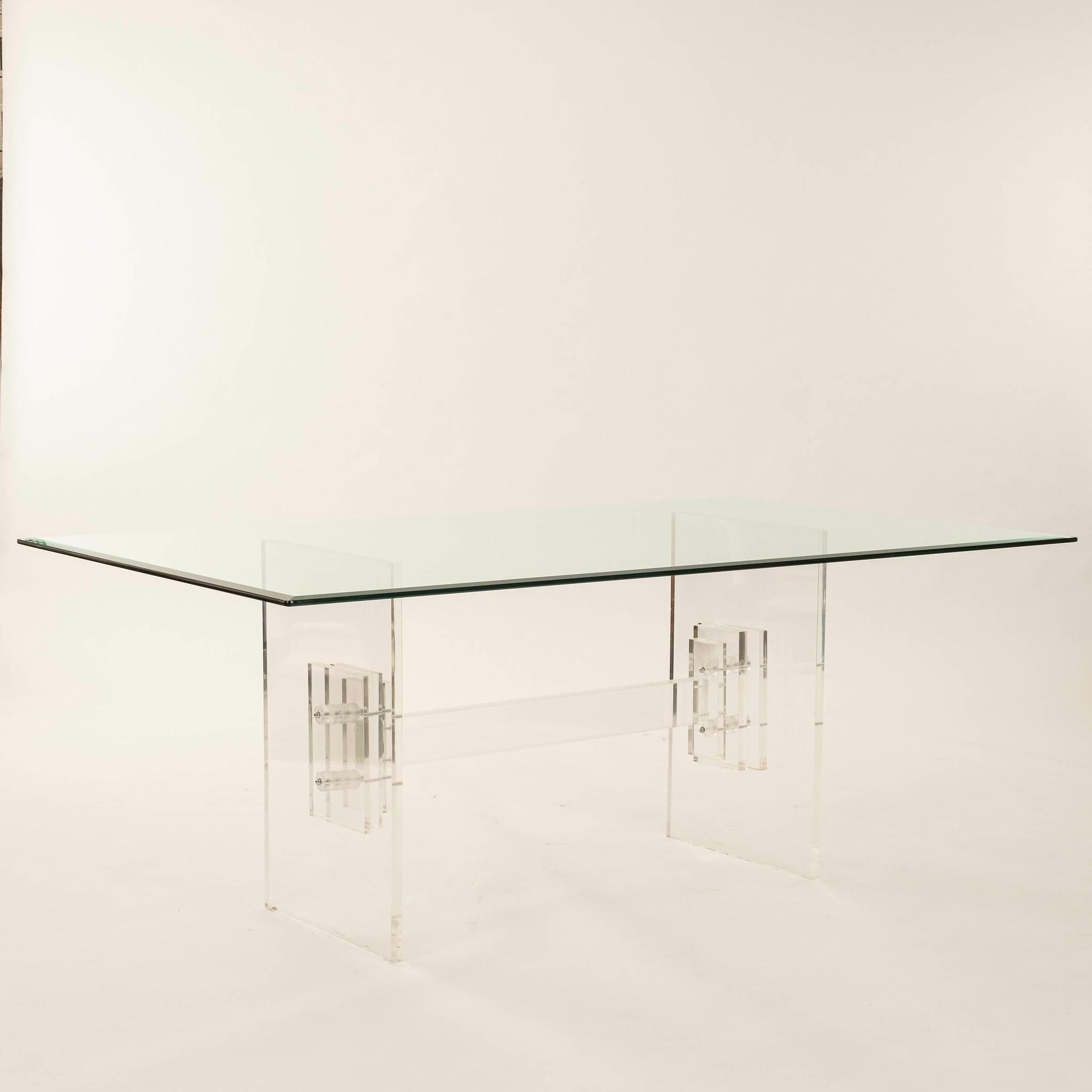 1970s Lucite and glass dining table featuring a base composed of interlocking lucite panels.