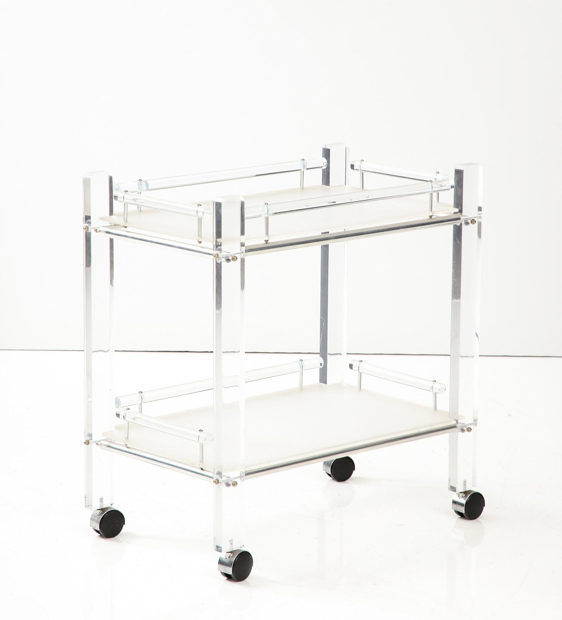 The Lucite framed bar cart supporting two tiers of removable trays all on wheels. 