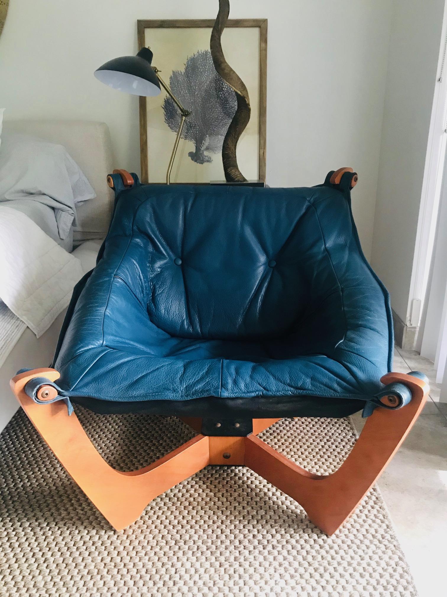 Scandinavian Modern lounge chair by Odd Knutsen, circa 1970s. Iconic sling chair with modernist four post frame design in molded plywood with teak finish and bronzed rivets. Chair features a an adaptable padded seat with a sling design in beautiful
