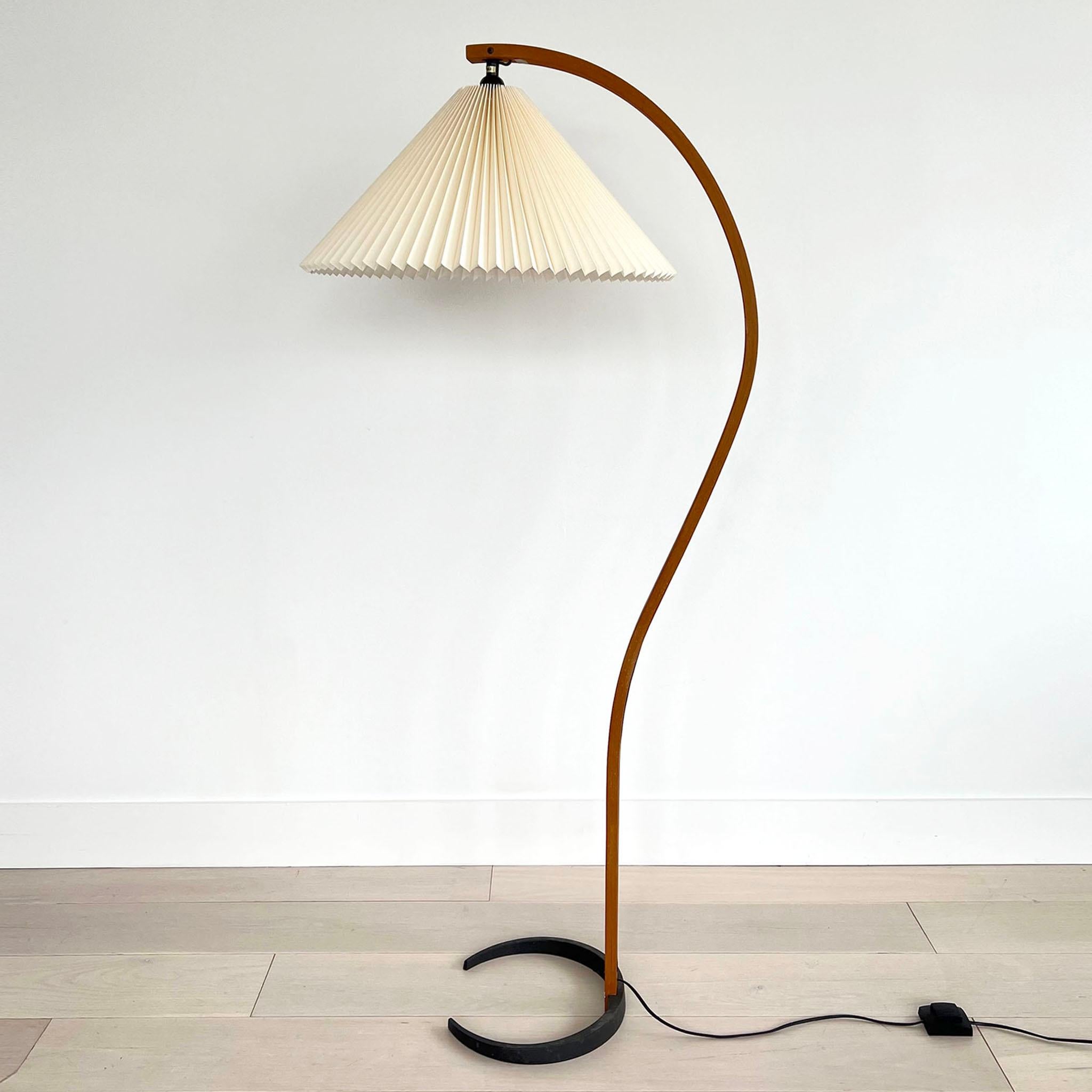 Mads Caprani Danish floor lamp, circa 1970's. This iconic lamp has a sculpted teak base with a steal base. The lampshade is brand new and produced in the original process and style.  The teak frame has some light scuffing/scratching. Stamped Caprani