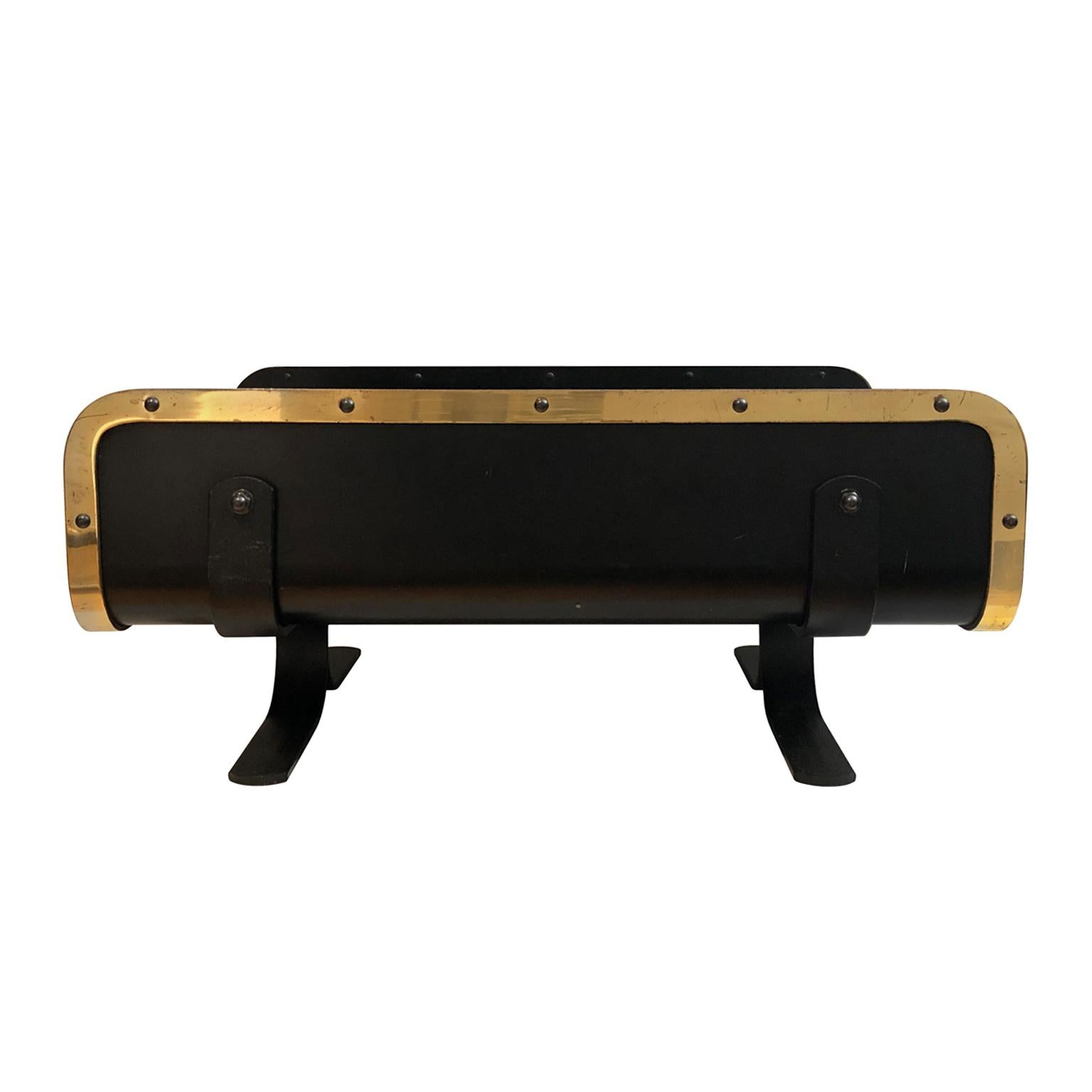 Black metal magazine rack/log stand with brass banding and bolt detail, USA, 1970s.