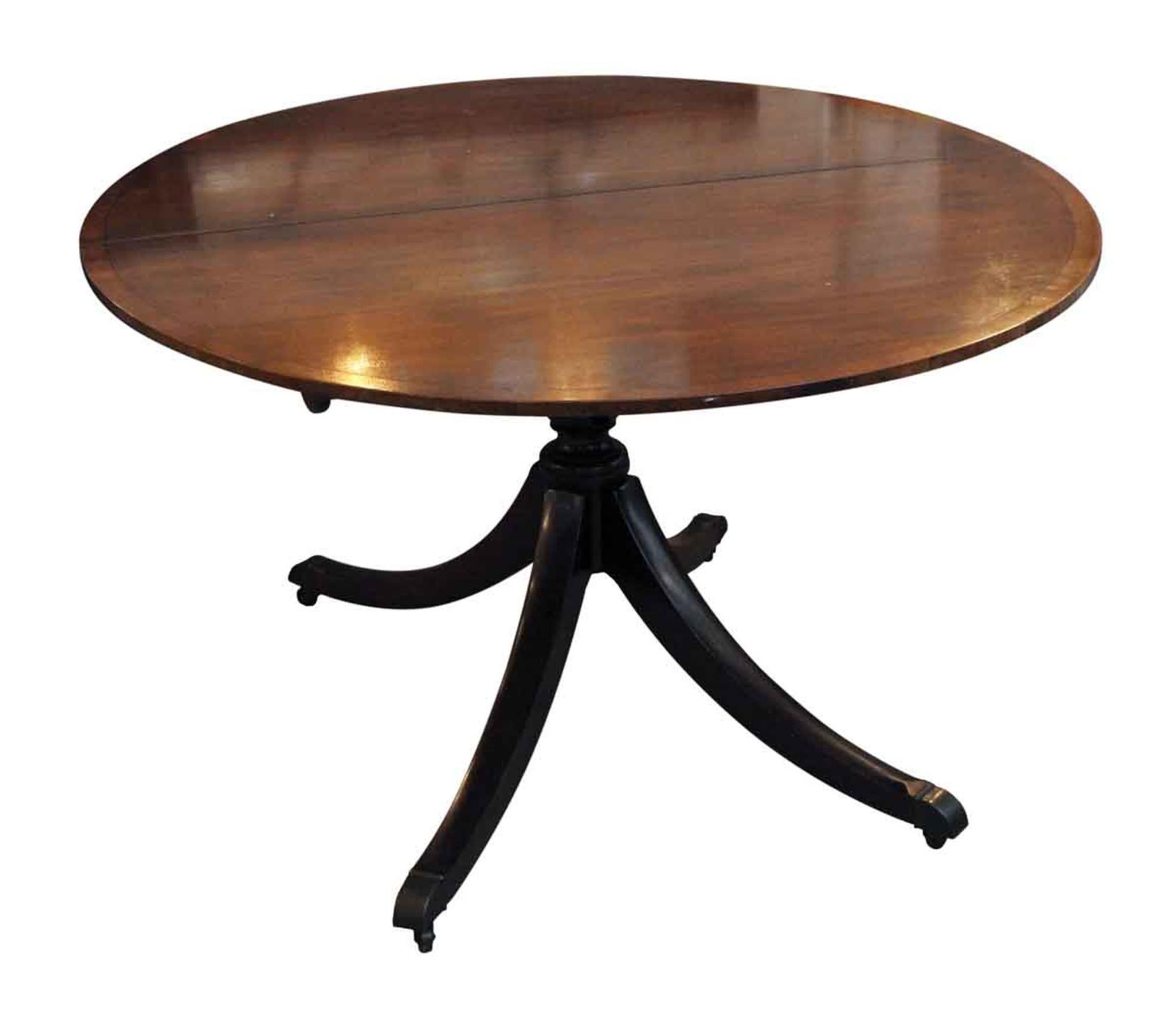 1970s Duncan Phyfe style oval mahogany dining table with two extensions on wheels. This can be seen at our 5 East 16th St location on Union Square in Manhattan.