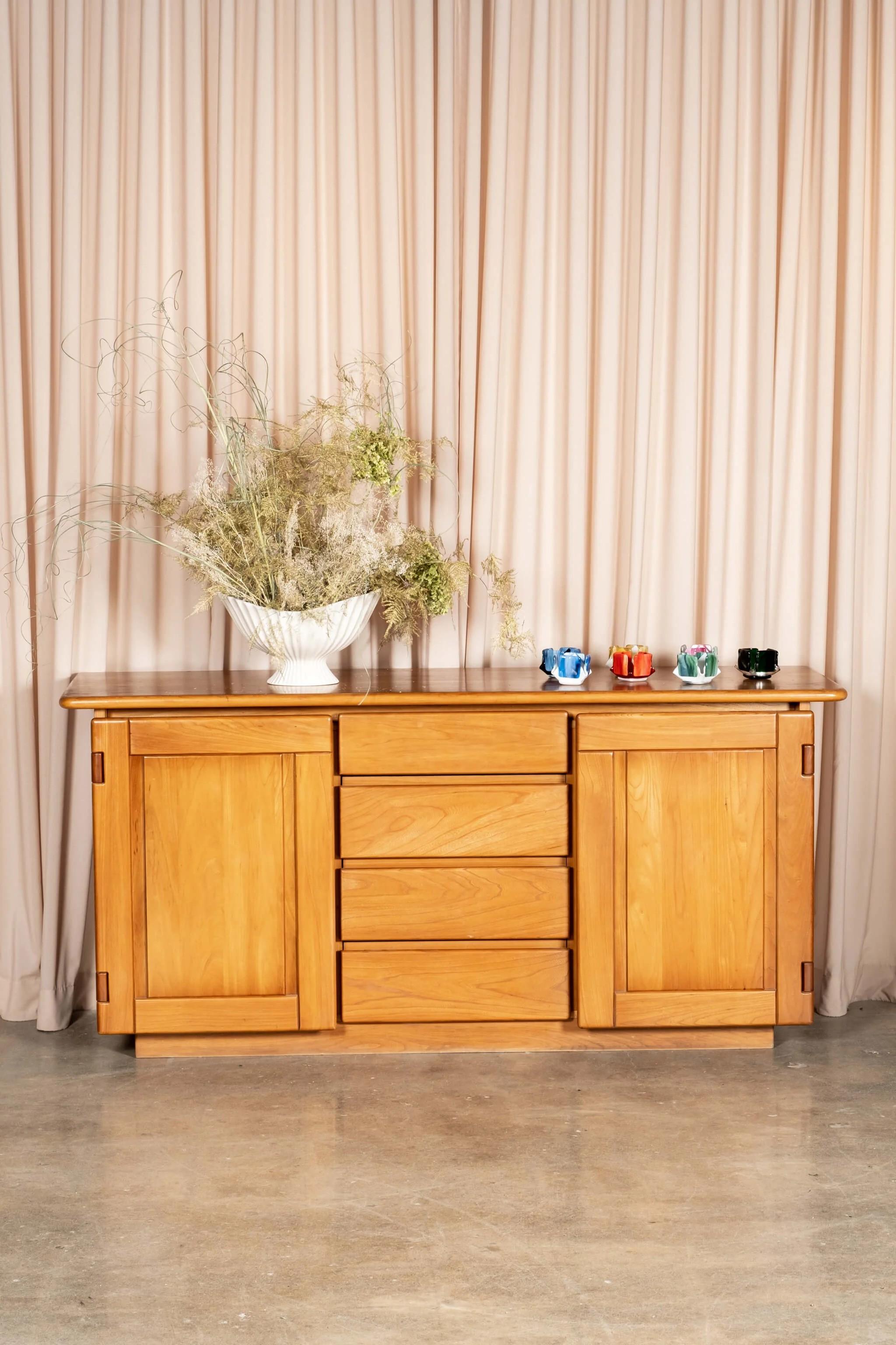 The impressive solid elm sideboard from French design house Maison Regain, in the style of Pierre Chapo, features 2 spacious doors and 4 drawers, all in their signature rounded wood. High quality fabrication and details, as is typical of Regain's