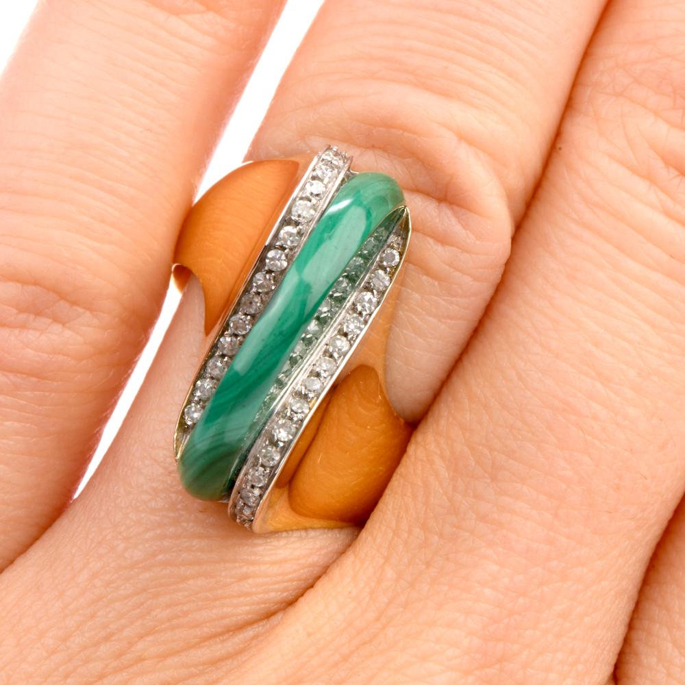 This modern 1970's abstract design ring is crafted in solid 18-karat yellow gold, weighing 9.8 grams and measuring 22mm x 12mm high. Exposing a half-circle disk of malachite besides 26 pave-set round-cut diamonds, weighing approximately 0.25 carats,