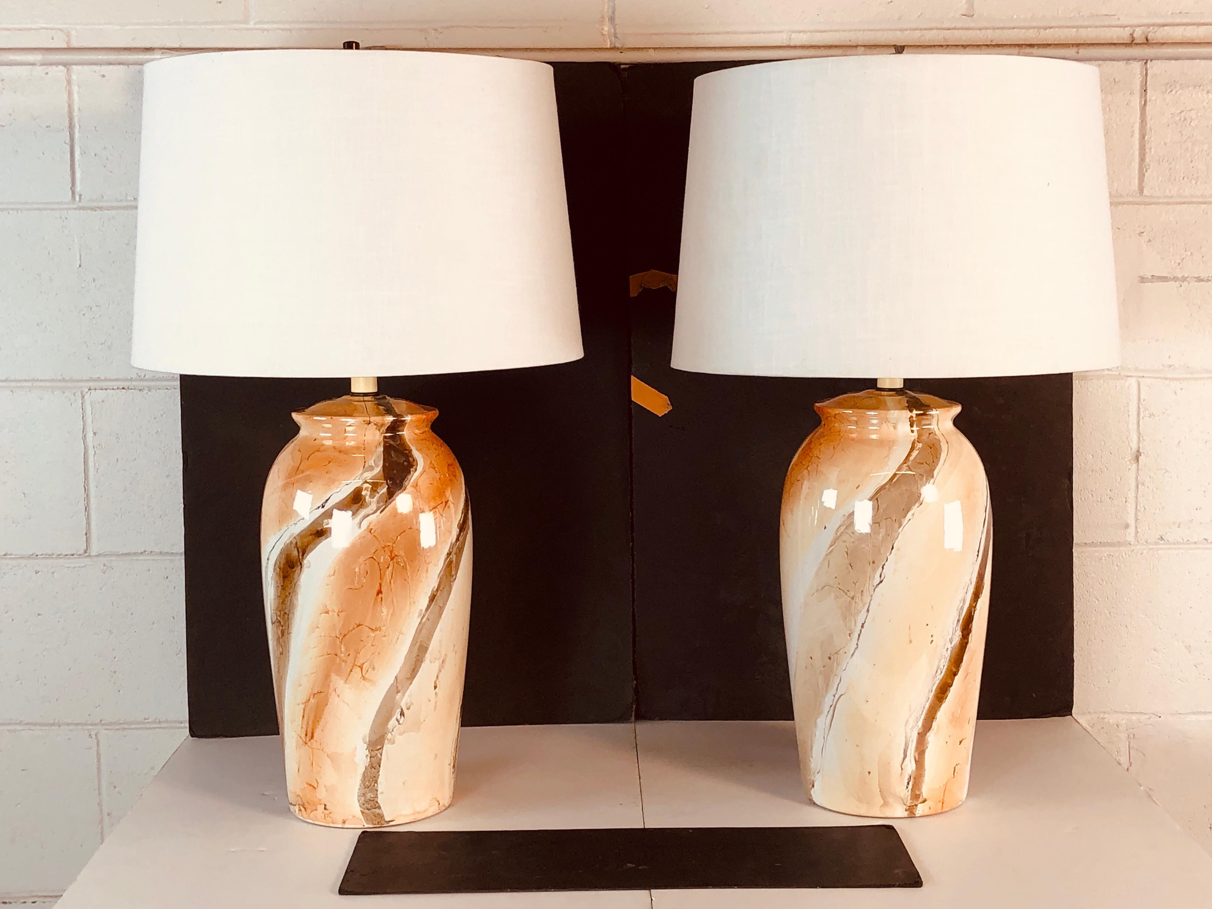 1970s pair of marble style tall ceramic table lamps. The lamps are wired for the US and in working condition. Socket, 21” height. Harp, 4.25” diameter x 9.5” height. No maker’s mark.
Shades are not included.