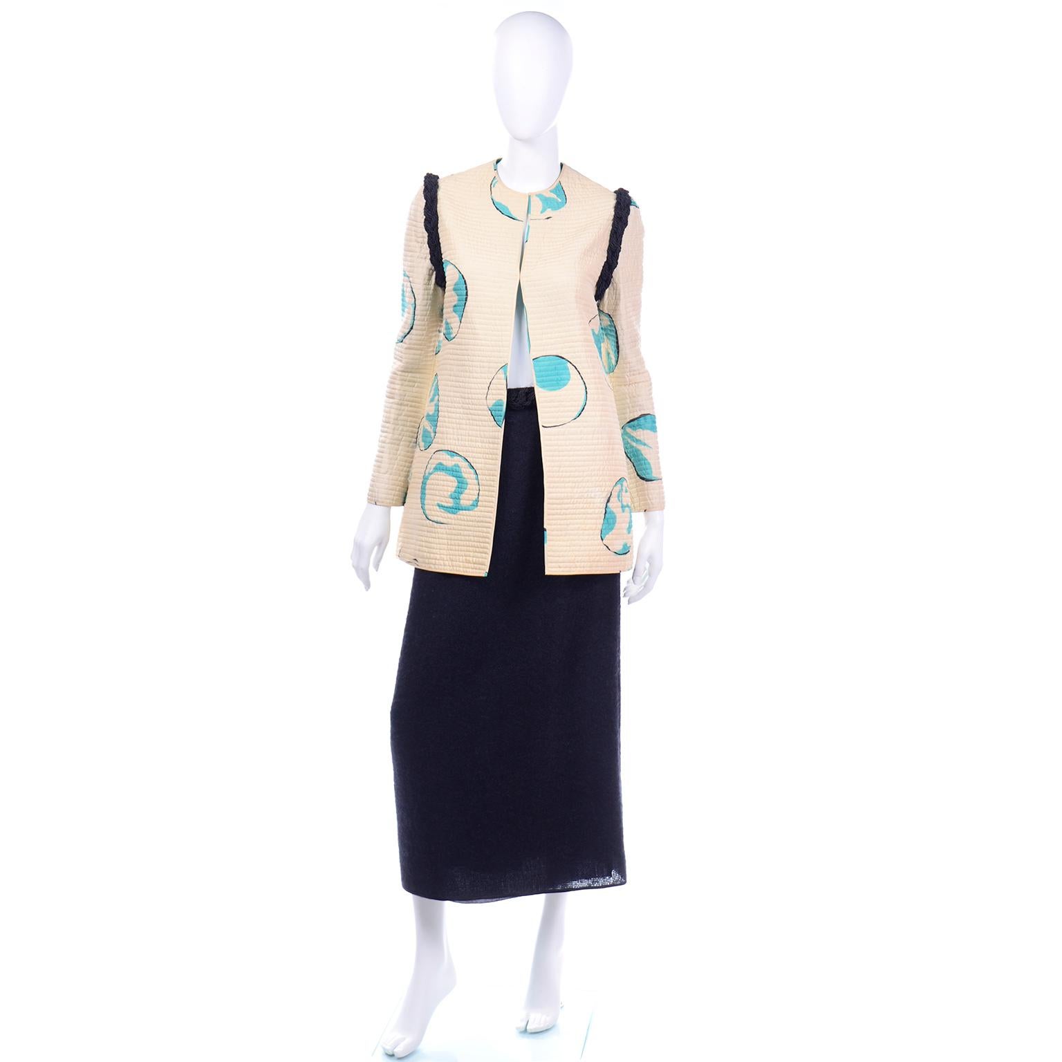 This is a rare vintage late 1970's or early 1980's Mary McFadden skirt suit with a quilted longline hand painted silk jacket. The jacket is cream with blue circles with black outlines that slightly resemble globes. These quilted silk jackets are