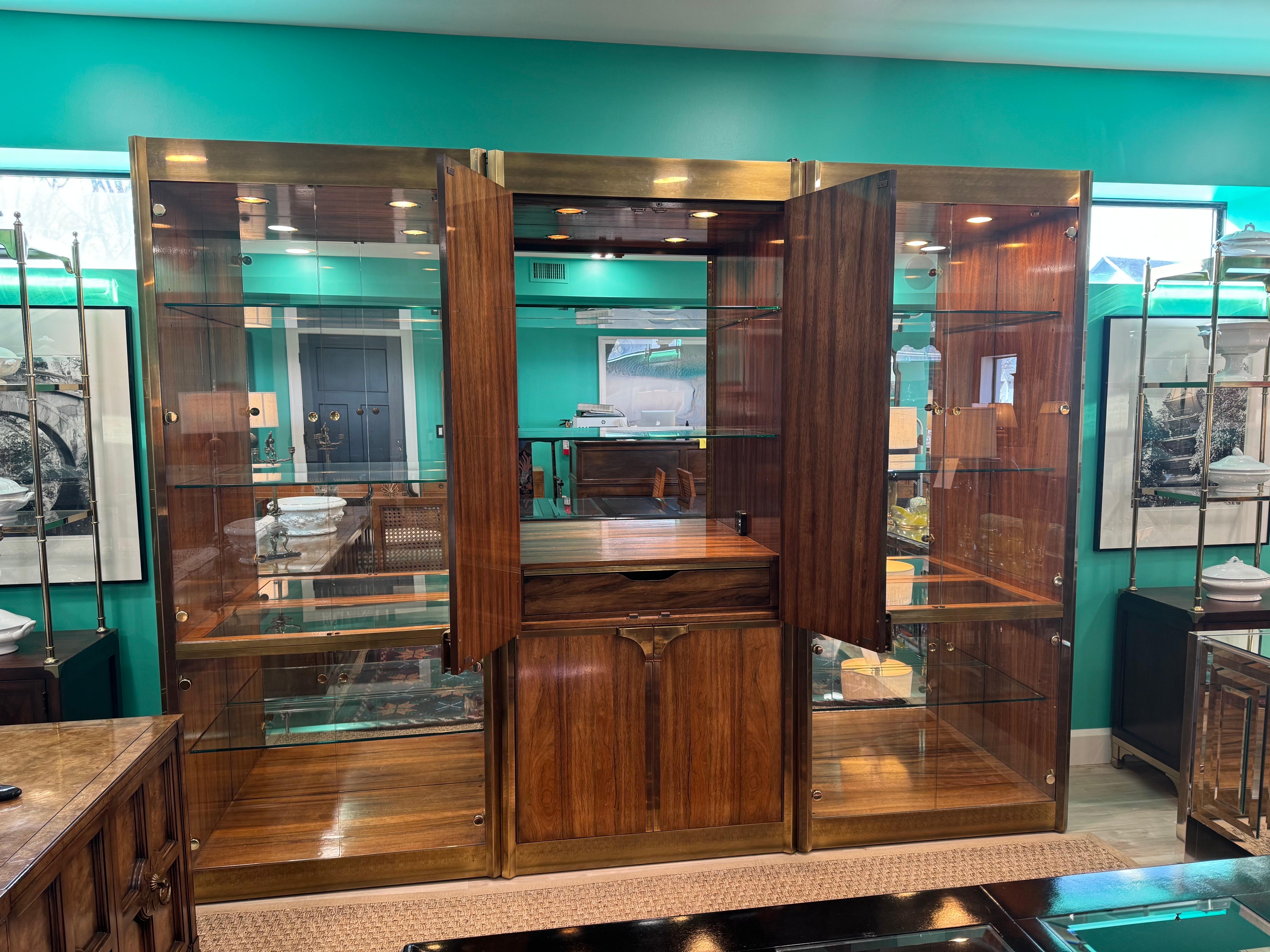 Spectacular Mastercraft Display Cases with Dry Bar Cabinet featuring Mirrored Backing, Bottle Storage and 2 Glass Front Side Display Cases Flanking in Zebrano Wood and Brass. 