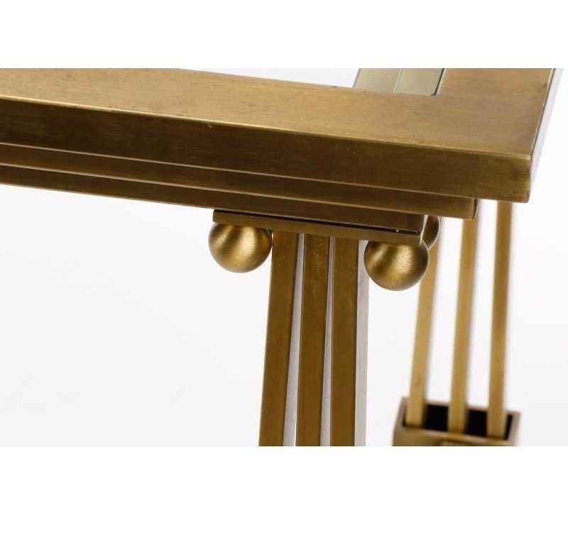 Architectural brass and glass dining table by Mastercraft, manufactured in the 1970s. The legs of this table have a nice columnar detail and glass insert that bring the whole design together. Brass with a beautiful lustrous patina and adds timeless