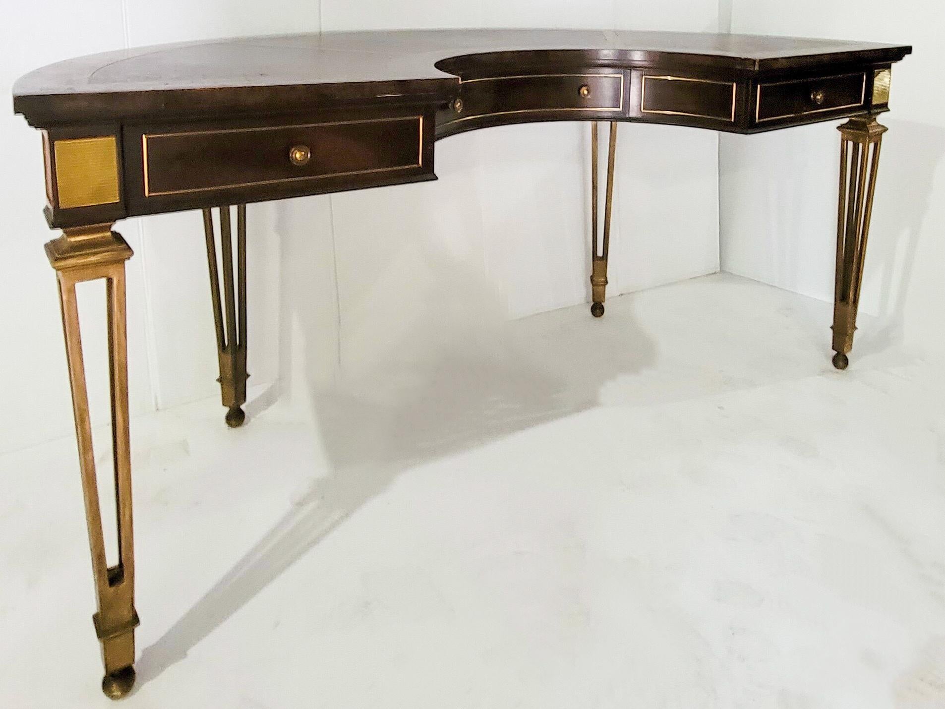 This is a good looking desk by Mastercraft. It has sleek, brass hairpin legs that support a burl top. The horseshoe shaped top has a leather writing surface. It is marked in the drawer. Floor to apron is 24”.