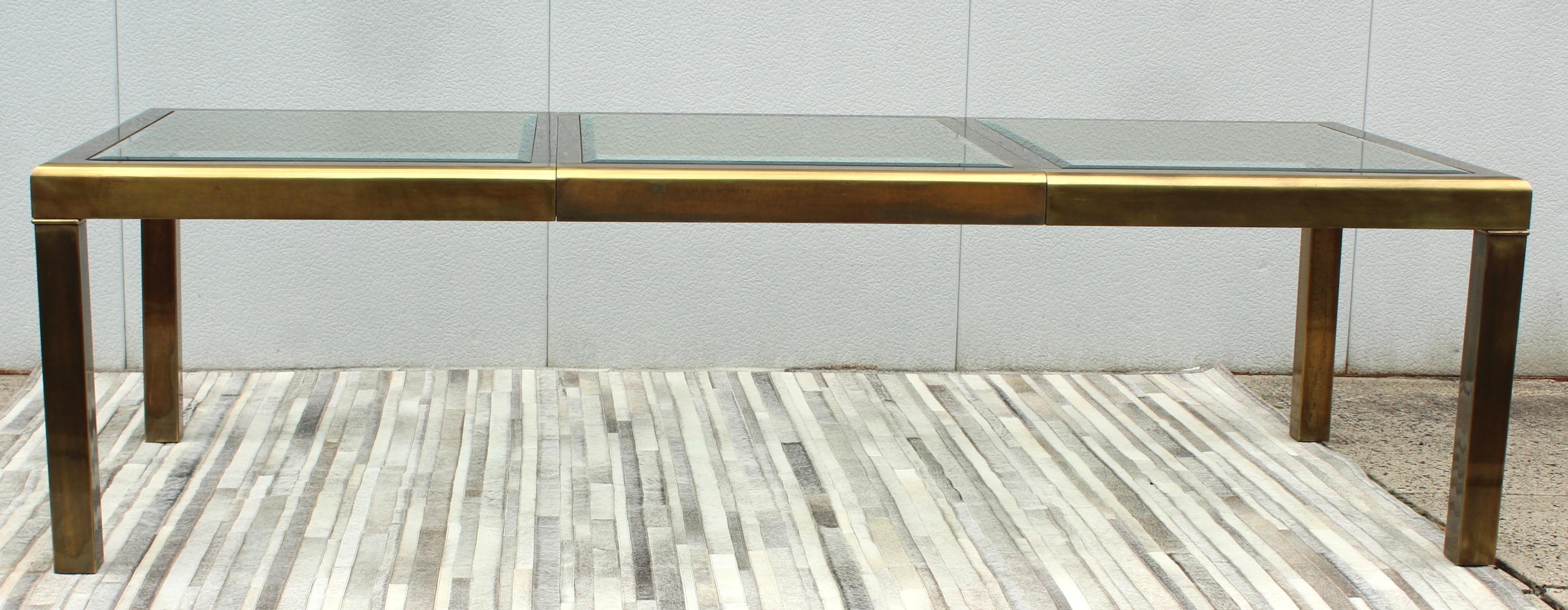 Stunning 1970's Mid-Century Modern brass dining table with beveled glass inserts and leaf, in vintage original condition with some wear and patina due to age and use, there is some wear to the brass on the leaf and legs.

Length without the leaf