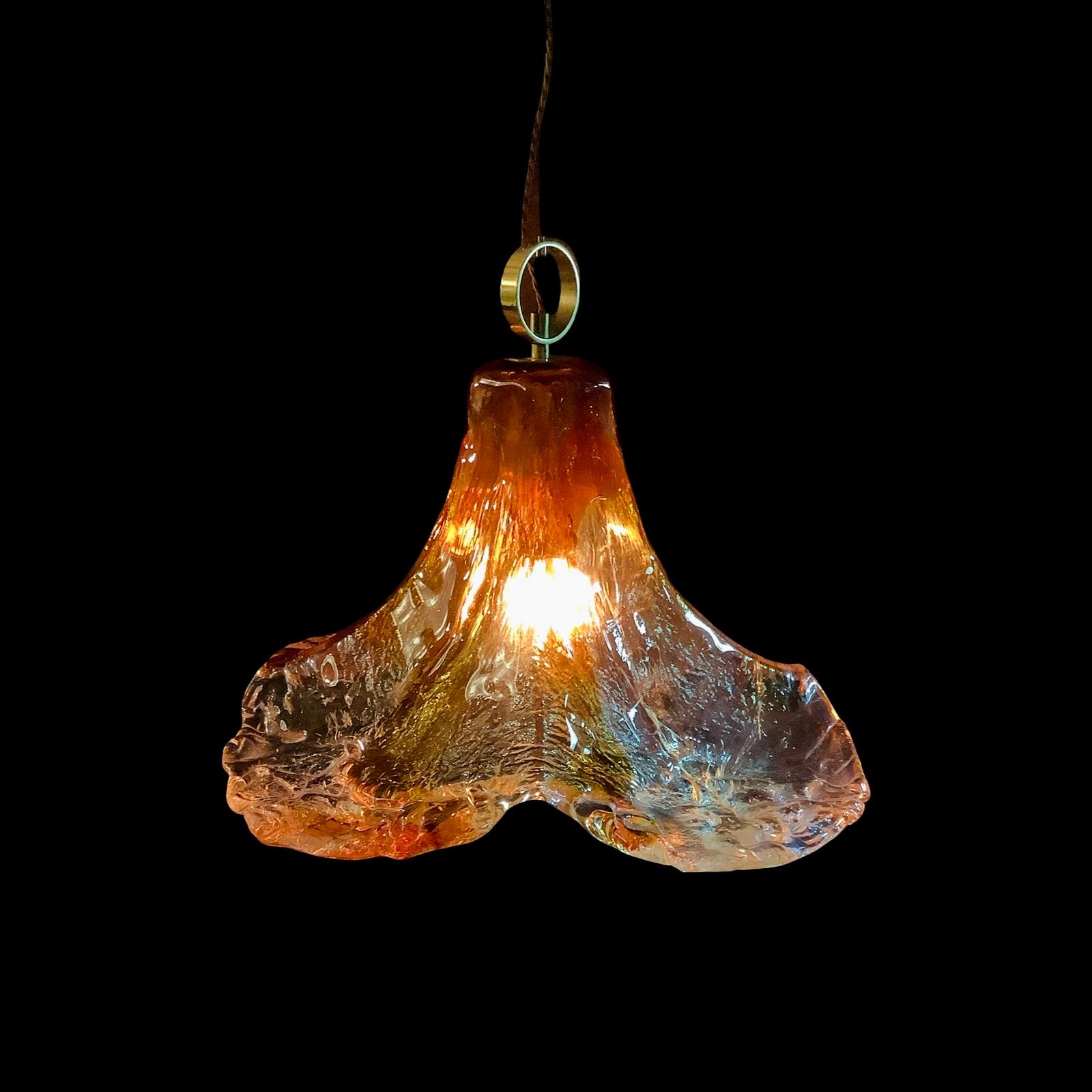 This vintage Murano glass pendant light by Mazzega is a rare collector’s piece that blends artistry and warmth.

Its handcrafted, one-piece glass shade features a stunning two-tone design; clear and amber glass that captures and diffuses light