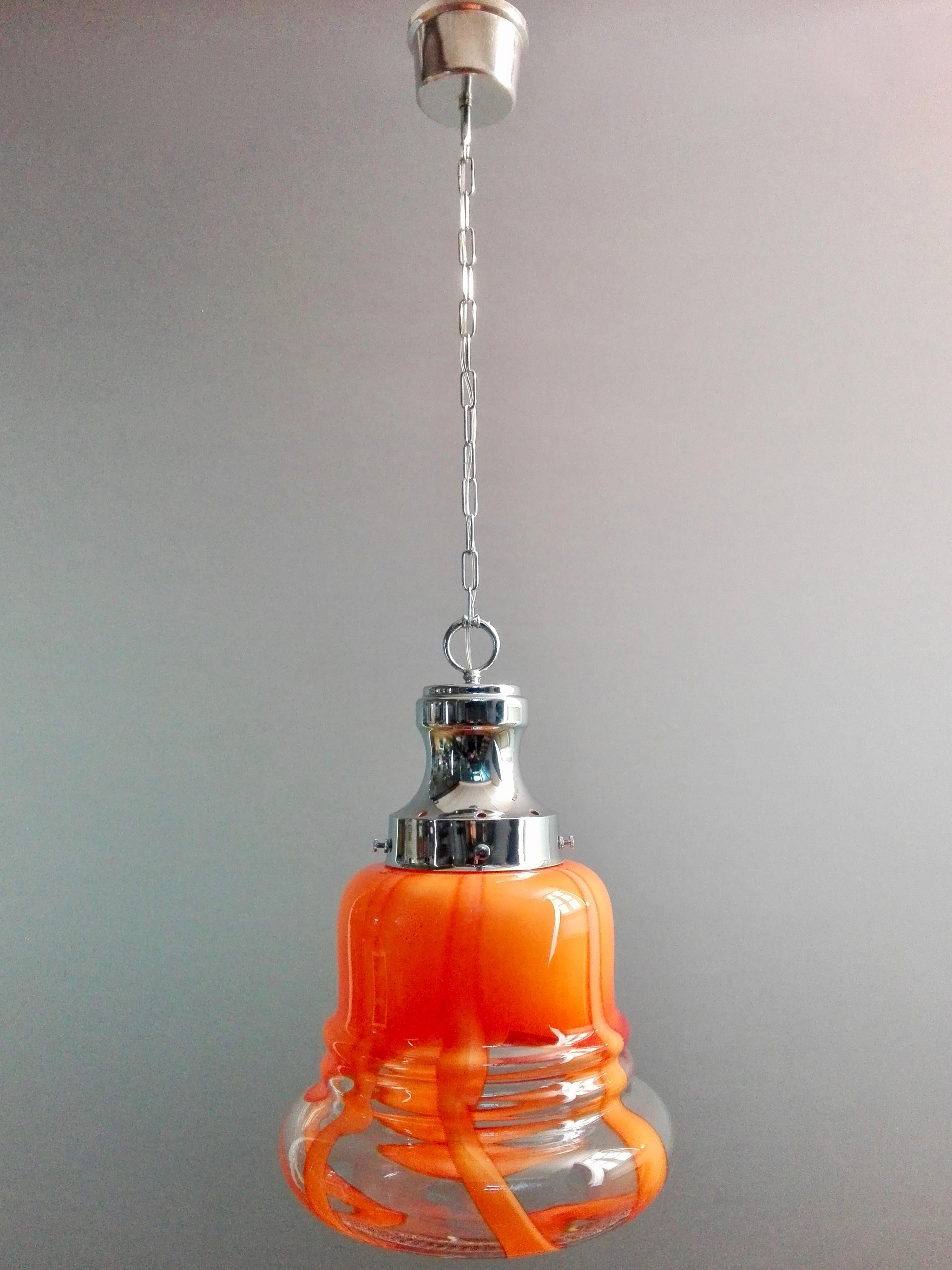 Beautiful 1970s Italian one-light pendant lamp in chrome and hand-blown Murano art glass in the style of Mazzega. The hand-blown glass shade, shaped with great skill, is clear and orange in various shades. With its design, it is surely a perfect