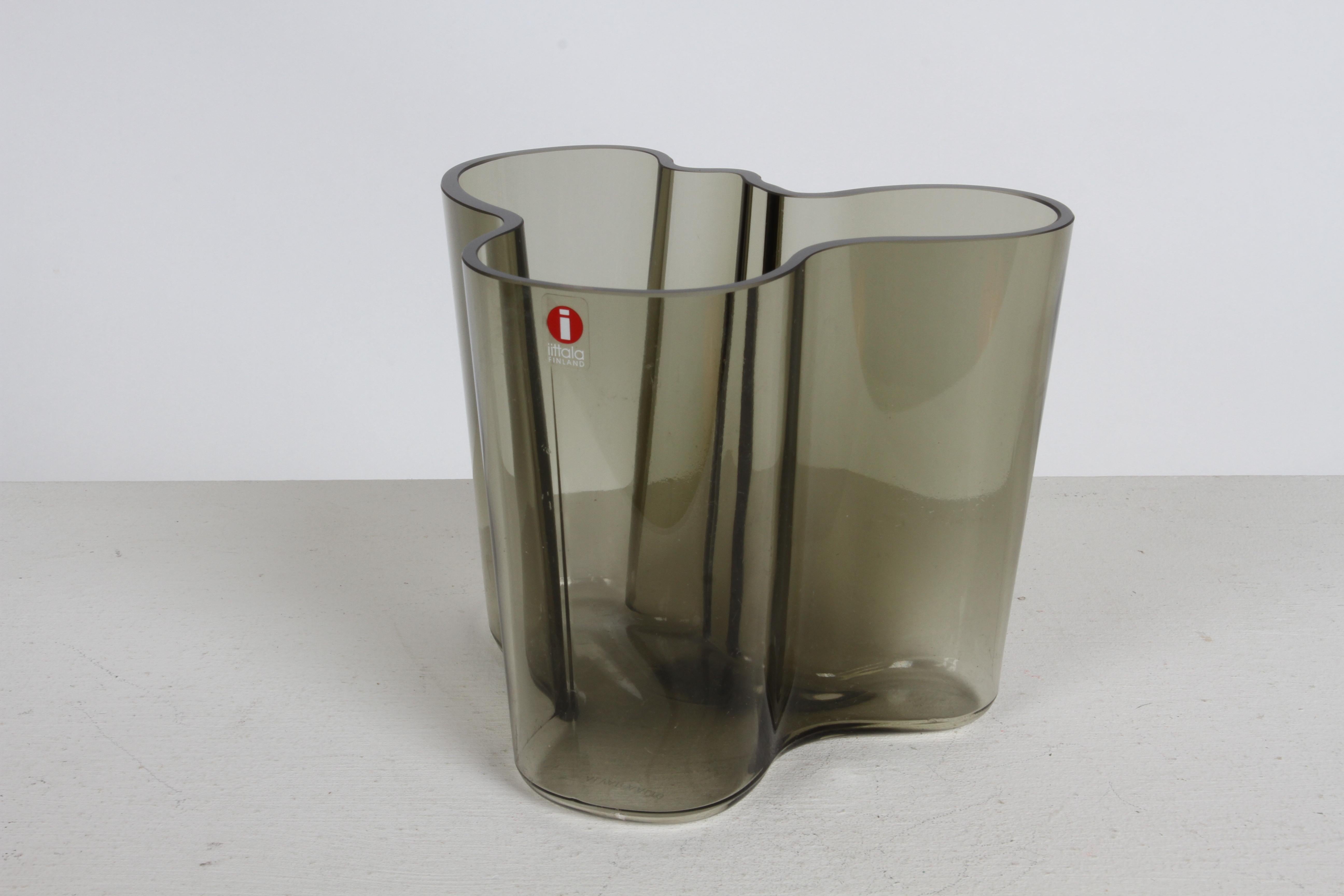 Die berühmte Mid-Century Alvar Aalto Savoy Vase 3030 in selten gesehenem rauchgrauem Glas von Iittala Finnland. Das originale Label ist erhalten, ebenso die geätzte Signatur von Alvar Aalto am Boden. 