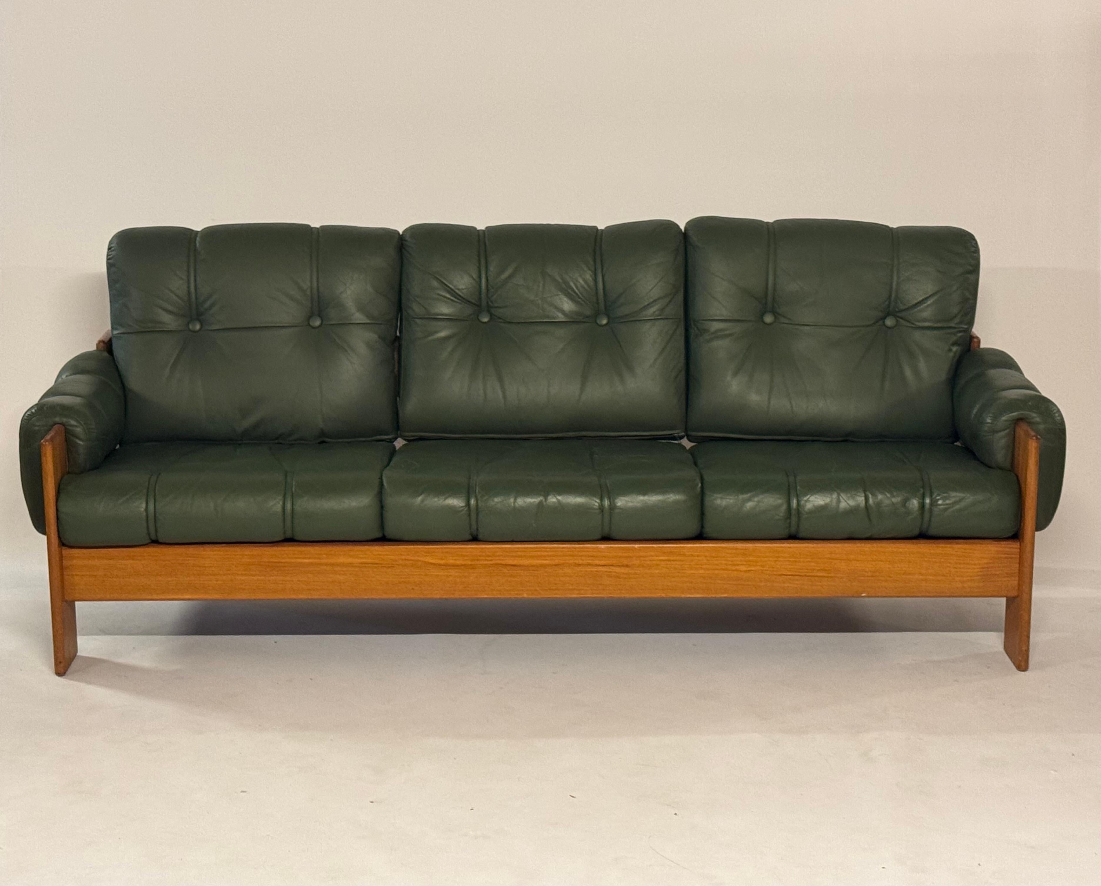 Uncommon find in the states, this 1970s Scandinavian MCM sofa by Kalustekiila of Finland, having the original high quality green tufted leather upholstery which does shows some wear, (see photos) and apparently has been redyed at some point. The